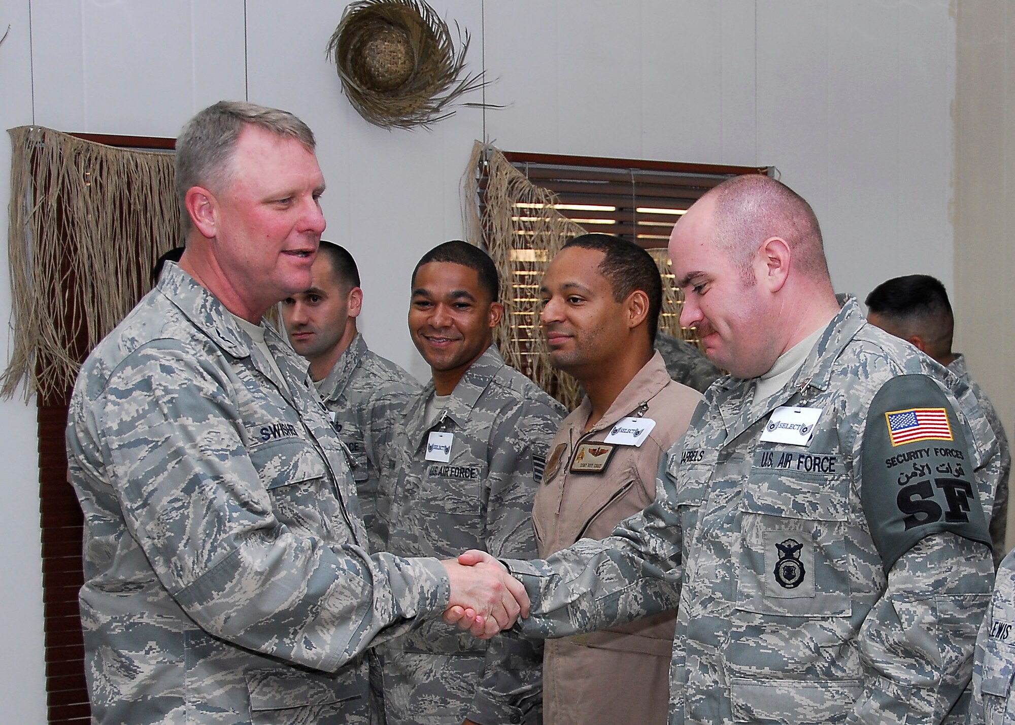 SOUTHWEST ASIA -- Colonel Robert Swisher, 386th Air Expeditionary Wing commander shakes the hand of Staff Sgt. Derek Jarrels, 386th Expeditionary Security Forces Squadron, one of 67 wing Airmen recently selected for promotion to master and technical sergeant prior to a ceremony here June 27. (U.S. Air Force photo/Staff Sgt. Patrick Dixon)