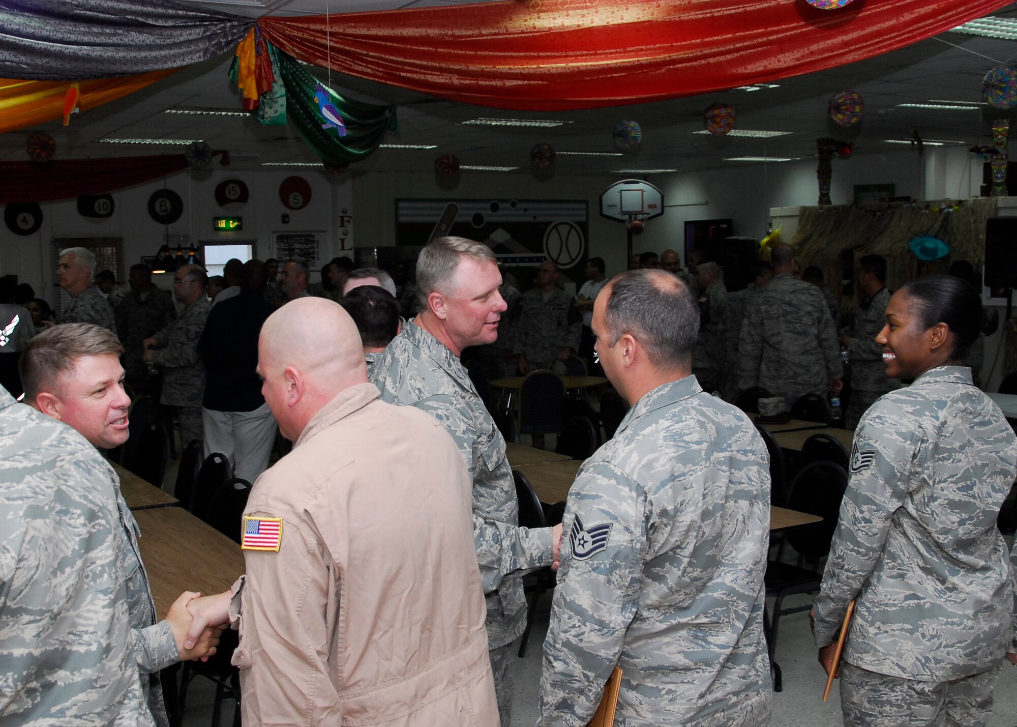 SOUTHWEST ASIA -- Colonel Robert Swisher, (center), 386th Air Expeditionary Wing commander and Chief Master Sgt. Carl Hunsinger, (left), 386th AEW command chief, shake the hands of some of the 67 wing Airmen selected for promotion to master and technical sergeant following a ceremony here June 27. (U.S. Air Force photo/Staff Sgt. Patrick Dixon)