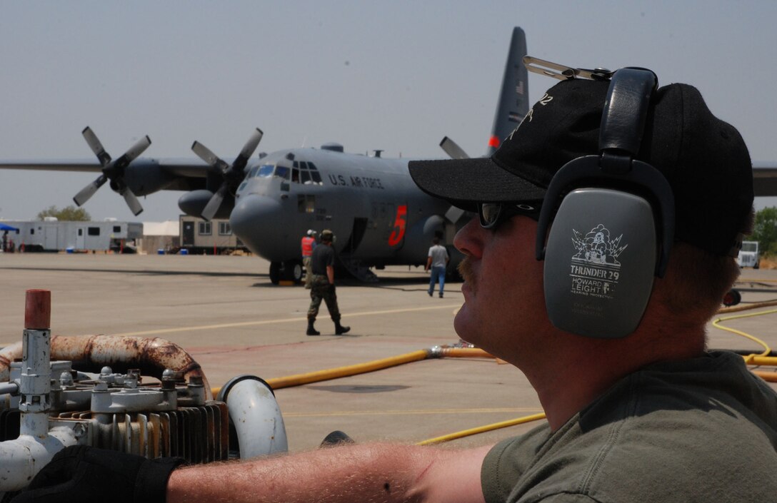 Michael Docklam, an aircraft structural repair specialist, watches as ground crews refill a C-130H Hercules with fire retardant prior to a firefighting mission June 29 at McClellan Airfield, Sacramento, Calif. Mr. Docklam is assigned to the 302nd Air Expeditionary Group. The 302nd AEG, responsible for eight aircraft, is currently fighting the Corral and Piute fires, each about 200 miles north and south of the California capital. As of 2:30 p.m. June 29, aircrews launched eight missions against the fires, dropping 24,000 gallons of fire retardant. The 302nd AEG is made up of the Air Force Reserve Command’s 302nd Airlift Wing, Peterson Air Force Base, Colo., and two Air National Guard units from the 153rd AW, Cheyenne, Wyo., and the 145th AW, Charlotte, N.C. (U.S. Air Force photo/Senior Airman Stephen Collier)