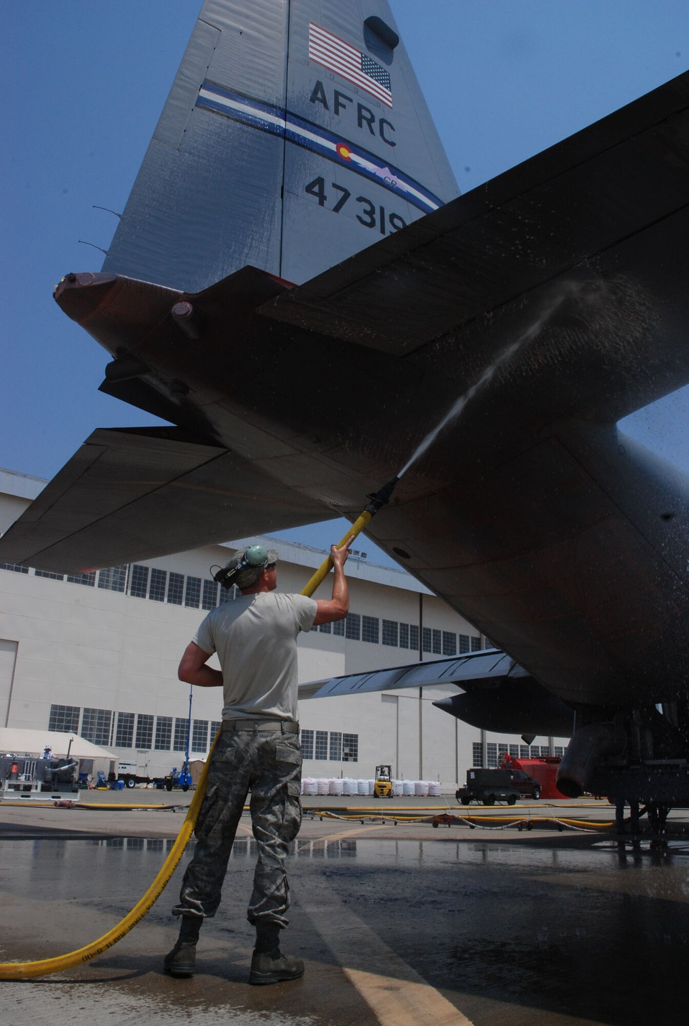 Staff Sgt. Josh Crooks, an Air Force reservist with the 302nd Airlift Wing, Peterson Air Force Base, Colo., washes down the ramp of a C-130H prior to a firefighting mission June 29 at McClelland Airfield in Sacramento, Calif. Sergeant Crooks and three 302nd AW aircraft and crews are assigned to the 302nd Air Expeditionary Group fighting the Corral and Piute wildfires fires near the California capital. As of 2:30 p.m. June 29, aircrews launched eight missions against the fires, dropping 24,000 gallons of fire retardant. The 302nd AEG includes the 302nd AW, and two Air National Guard units from the 153rd AW, Cheyenne, Wyo., and the 145th AW, Charlotte, N.C. (U.S. Air Force photo/Senior Airman Stephen Collier)