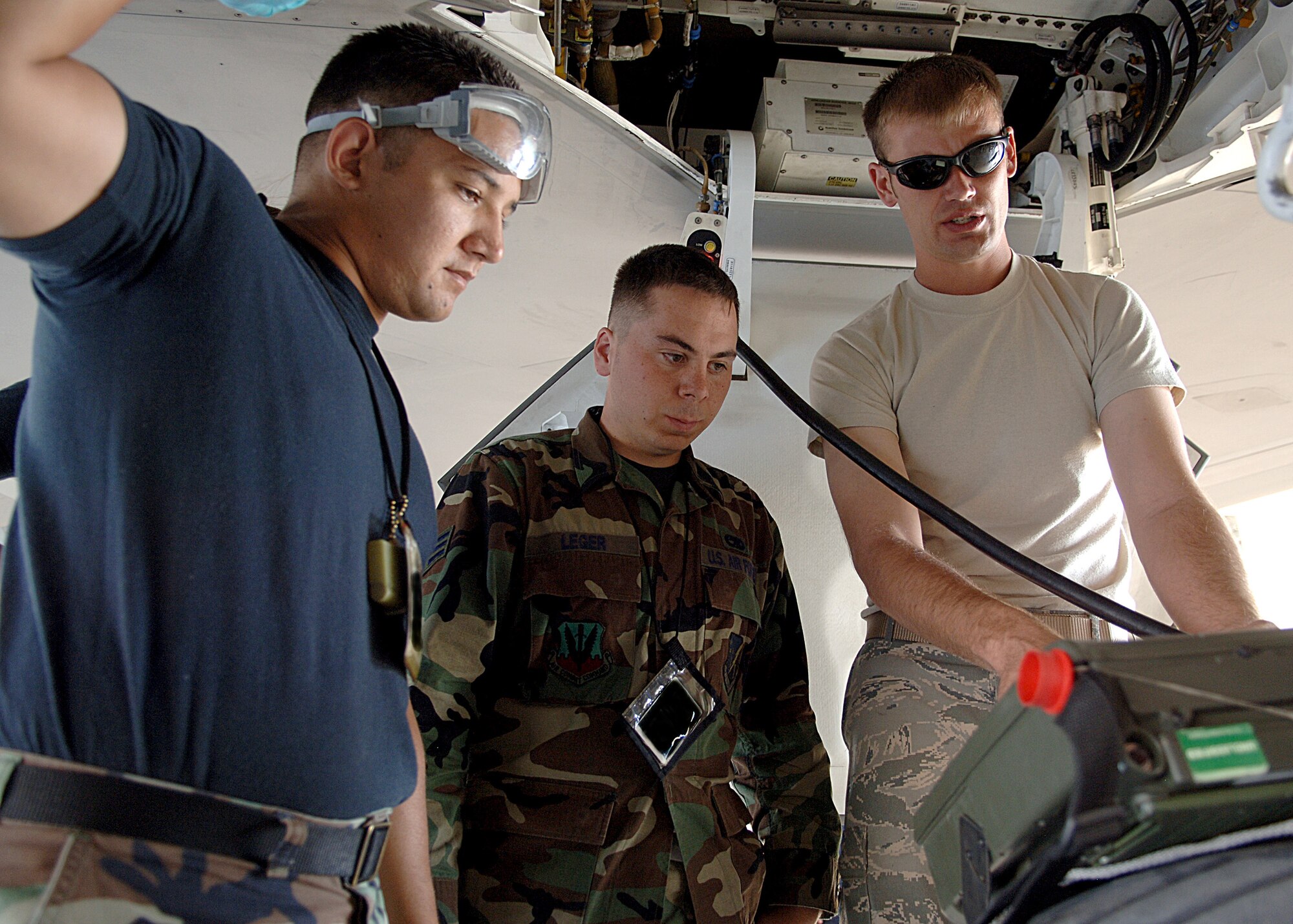 Staff Sgt. John Bryan, Senior Airman Mark Leger and Senior Airman Leon Archuleta all of the 49th Aircraft Maintenance Squadron run checks on the F-22A Raptor using the personal maintenance aid at Holloman Air Force Base, N.M.  (U.S. Air Force photo/Airman 1st Class John Strong) 
  