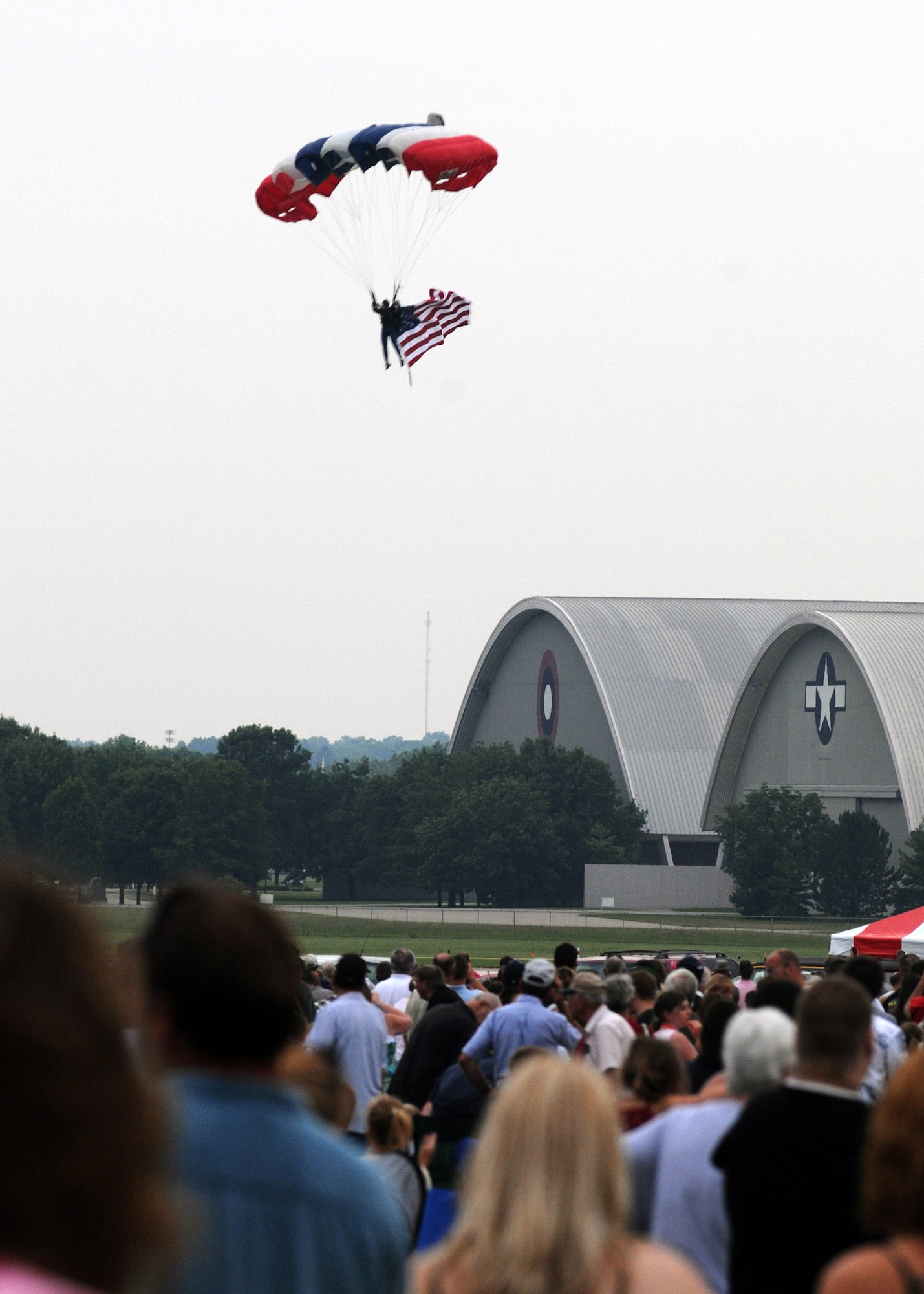 A parachutist prepares to land after jumping with the American flag during the playing of the national anthem during the 4th annual Freedom's Call Tattoo June 27 on the grounds of the National Museum of the U.S. Air Force in Dayton, Ohio. More than 75,000 peole came out for the event that consisted of aircraft fly overs, food and music by the Air Force Band of Flight, Charlie Daniels Band and local performers.  (U.S. Air Force photo/Staff Sgt Joshua Strang) 