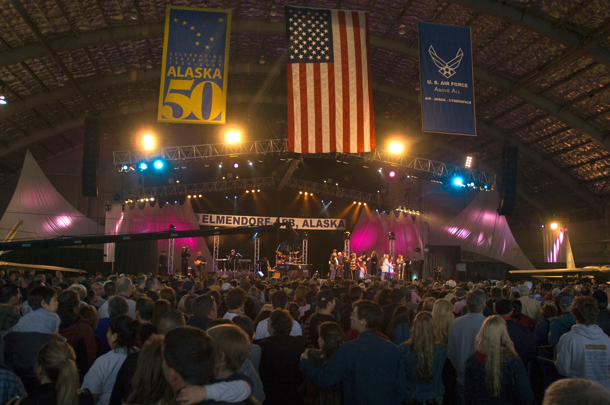 Wynonna Judd brings family members on stage during a live teleconference with deployed Airmen during Alaska's Operation Gratitude concert June 27 at Elemendorf Air Force Base, Alaska. This concert was the official kick off to the "We're In" weekend, celebrating Alaska's 50 years of statehood. More than 10,000 people attended the event. (U.S. Air Force photo/Airman 1st Class David Carbajal) 