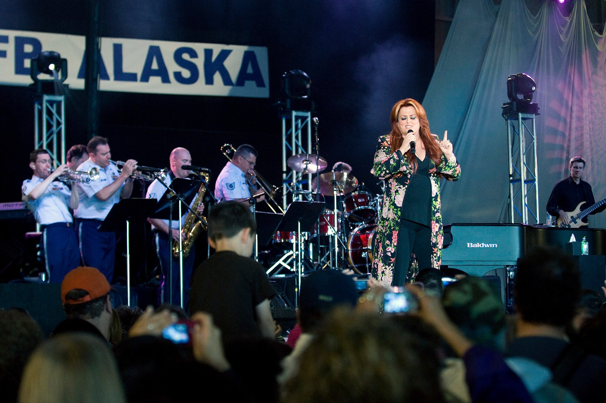 Wynonna Judd performs with the U.S. Air Force Band of the Pacific for a military and Alaskan crowd at the Alaska's Operation Gratitude concert June 27 at Elemendorf Air Force Base, Alaska. The concert was the official kick off to the "We're In" weekend, celebrating Alaska's 50 years of statehood. More than 10,000 people attended the event. (U.S. Air Force photo/Senior Airman Jonathan Steffen) 