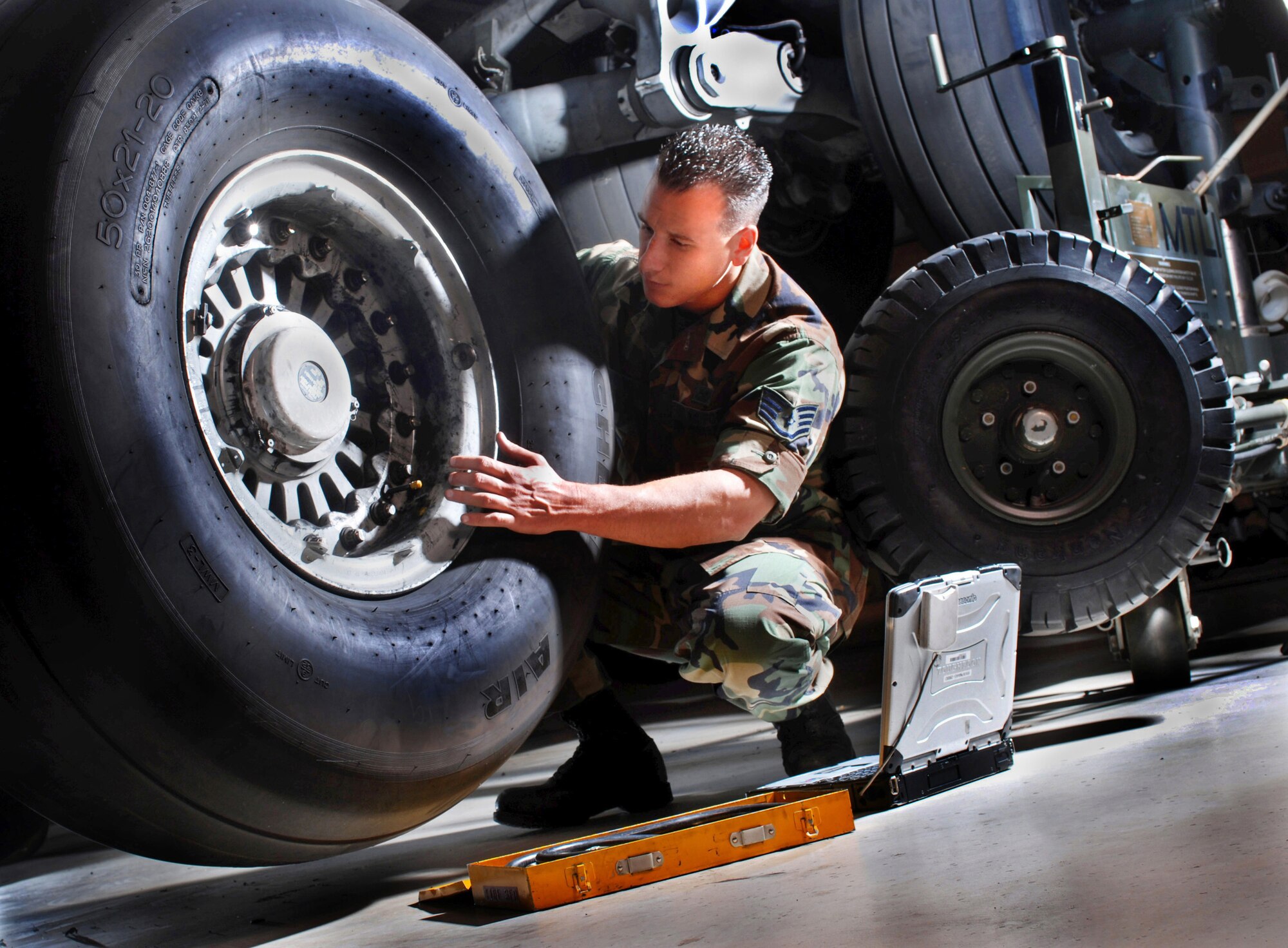 Staff Sgt. Brian Hicks, an aircraft mechanic from the 452nd Maintenance Squadron, checks the condition of a tire on a C-17 Globemaster III cargo aircraft at March Air Reserve Base, Calif. The aircraft is sitting on jack stands while undergoing routine inspection. (U.S. Air Force photo by Val Gempis)  

