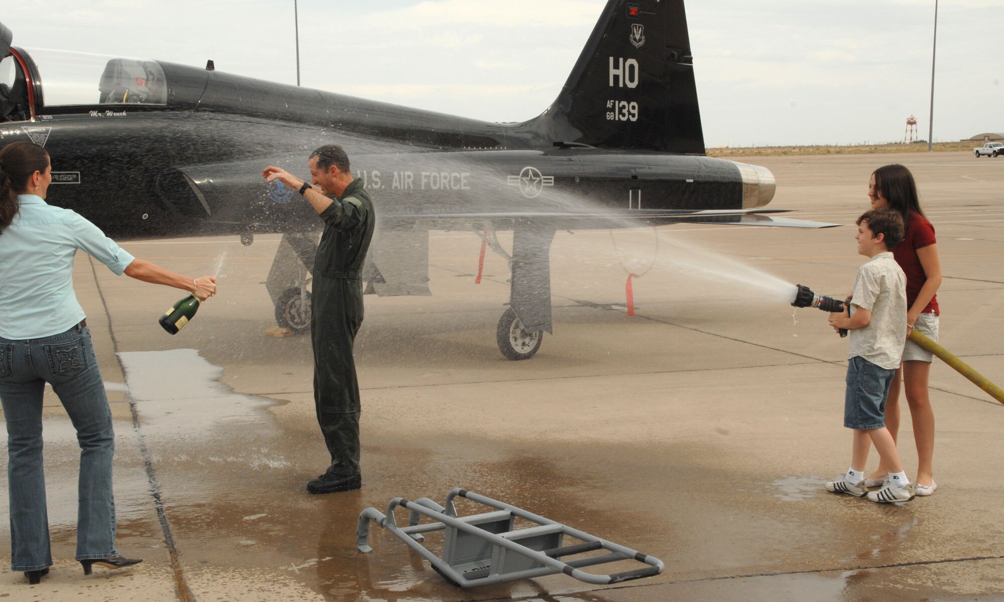 Col. John K. Forsythe is sprayed with water and champagne by his family after his last flight at Holloman Air Force Base, N.M., June 27. Spraying the pilot after a fini flight is an Air Force tradition.(U.S. Air Force photo/Airman 1st Class Jamal Sutter)