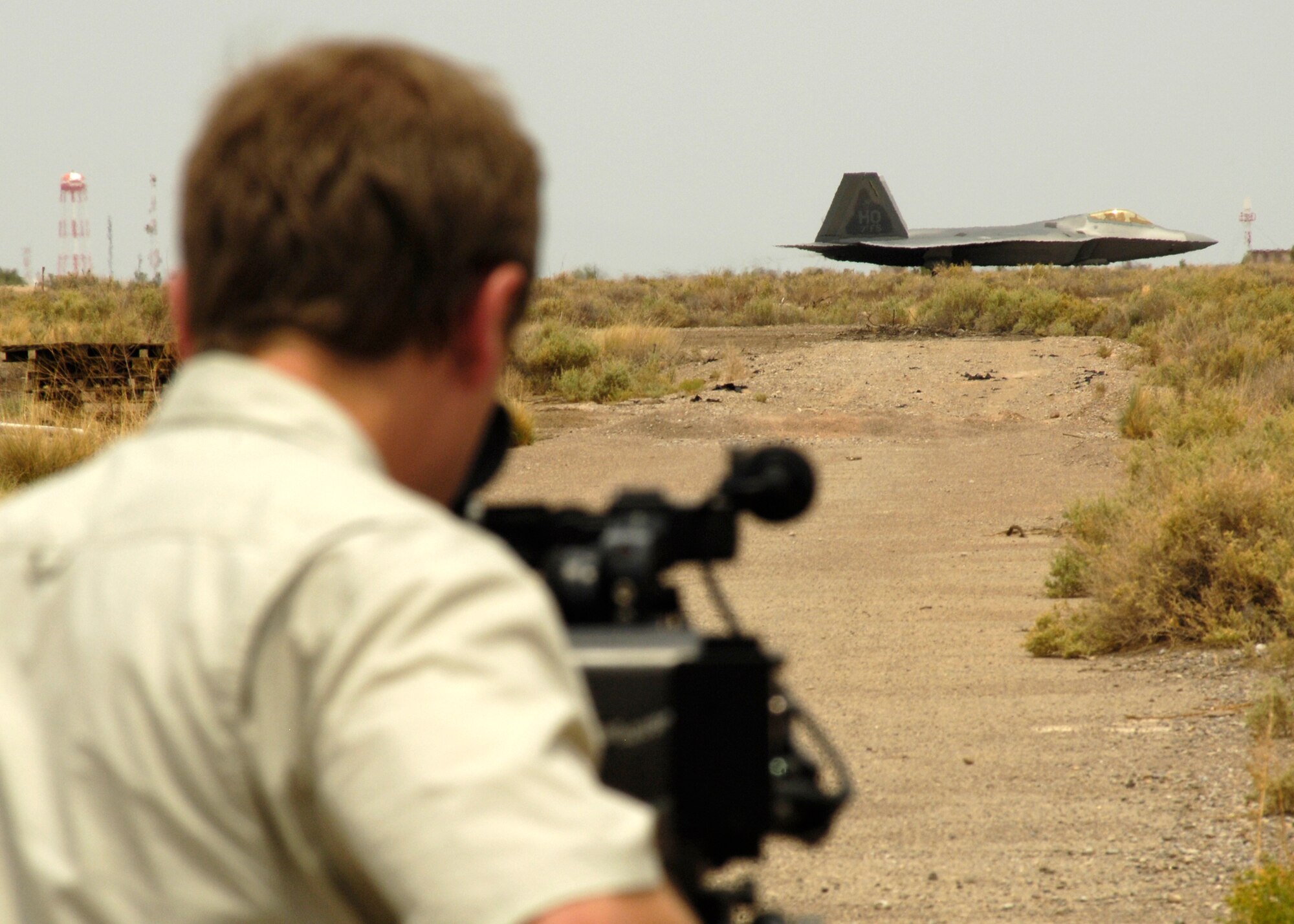 Mr. Mark Stevenson, producer and secondary cameraman, documents an F-22A Raptor taxi at Holloman Air Force Base, N.M., June 25. Mr. Stevenson came to Holloman to film documentary segments about the F-22A Raptor and the QF-4 drone for Discovery Channel Canada's "Daily Planet" show. (U.S. Air Force photo/Airman 1st Class Michael Means)