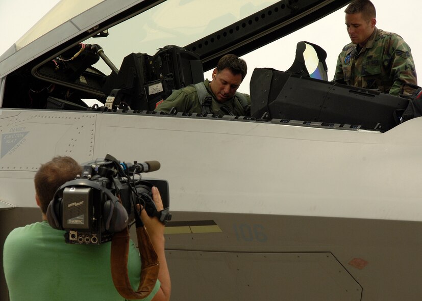 Mr. Mark Foerster, freelance cameraman, documents Lt. Col. Craig Baker, 7th Fighter Squadron director of operations, speaks with Senior Airman Audrey Howell, 49th Aircraft Maintenance Squadron crew chief, as they prepare for a sortie at Holloman Airforce Force Base, N.M., June 25. Mr. Foerster came to Holloman to film documentary segments about the F-22A Raptor and the QF-4 drone for Discovery Channel Canada's "Daily Planet" show. (U.S. Air Force photo/Airman 1st Class Michael Means)