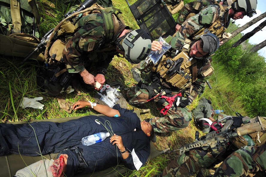 MOODY AIR FORCE BASE, Ga. -- Staff Sgt. Wes Loignon and Senior Airman Jacob Schaumberg, 38th Rescue Squadron pararesuemen, prepare to give Tech. Sgt. Andrea Kirks, a 910th Medical Squadron EMT from Youngstown Air Reserve Station, Ohio, an intravenous line here June 27. Due to Sergeant Kirks' simulated injury, an IV is needed to prevent shock. (U.S. photo by Senior Airman Schelli Jones)