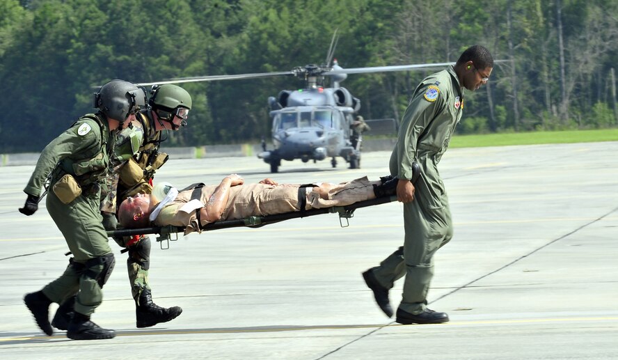 MOODY AIR FORCE BASE, Ga. -- Staff Sgt. Gary Miller, 41st Rescue Squadron flight engineer, Senior Airman Anthony Deroest, 38th Rescue Squadron pararescueman, and Capt. Joseph Pugh, 38th Rescue Squadron flight doctor, carry Staff Sgt. Victor Jeng, 41st Rescue Squadron aerial gunner, a mock casualty, onto an HC-130P King during a mass casualty exercise here, June 27. The patients were loaded onto the aircraft to be medically evacuated as part of the exercise. (U.S. Air Force photo by Senior Airman Elizabeth Rissmiller)