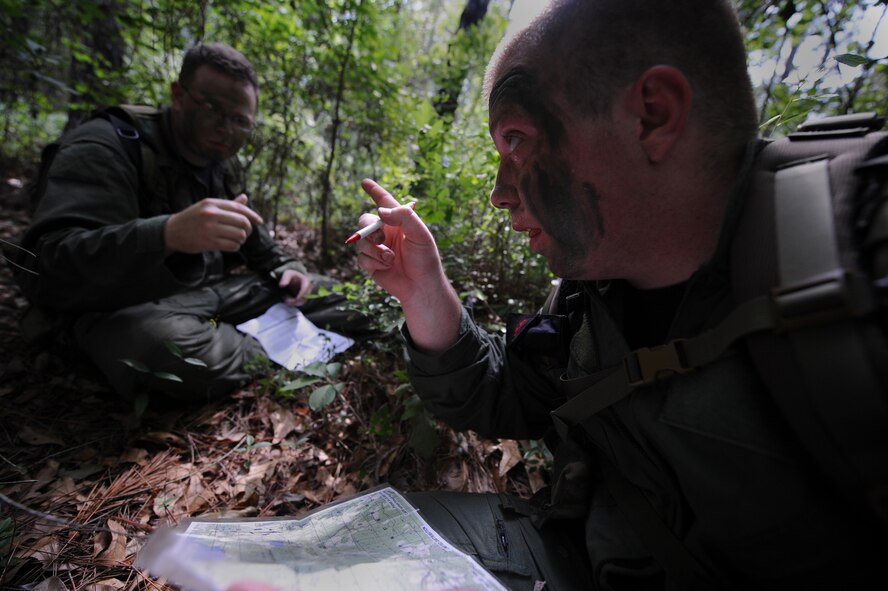 MOODY AIR FORCE BASE, Ga. -- Senior Airman George Horton, 41st Rescue Squadron flight engineer, right, speaks to Senior Airman Chris Reynolds, 71st Rescue Squadron load master, about locations on the map during survival, evasion, resistance, escape training here June 16. This course provided the students with training in survival skills, evading capture, recovery and dealing with captivity. (U.S. Air Force photo by Senior Airman Gina Chiaverotti) 

