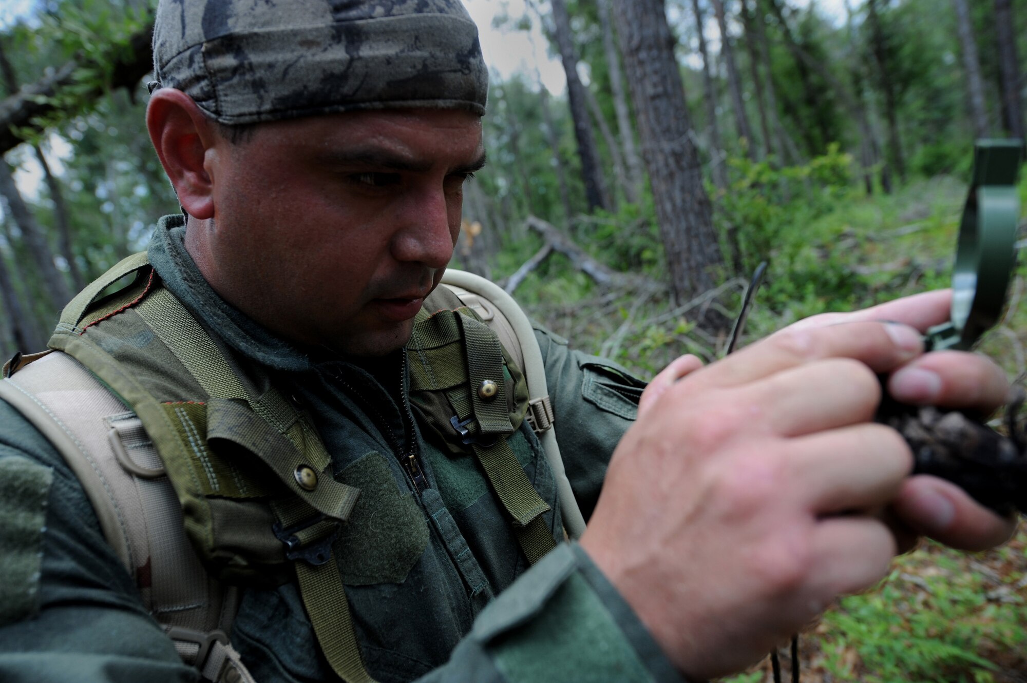 MOODY AIR FORCE BASE, Ga. -- Staff Sgt. Mario Munoz, 41st Rescue Squadron flight engineer, uses a compass to navigate from point-to-point during survival, evasion, resistance, escape (SERE) training here June 16. All pilots and aircrew must complete SERE training periodically to be qualified for flying status. (U.S. Air Force photo by Senior Airman Gina Chiaverotti)