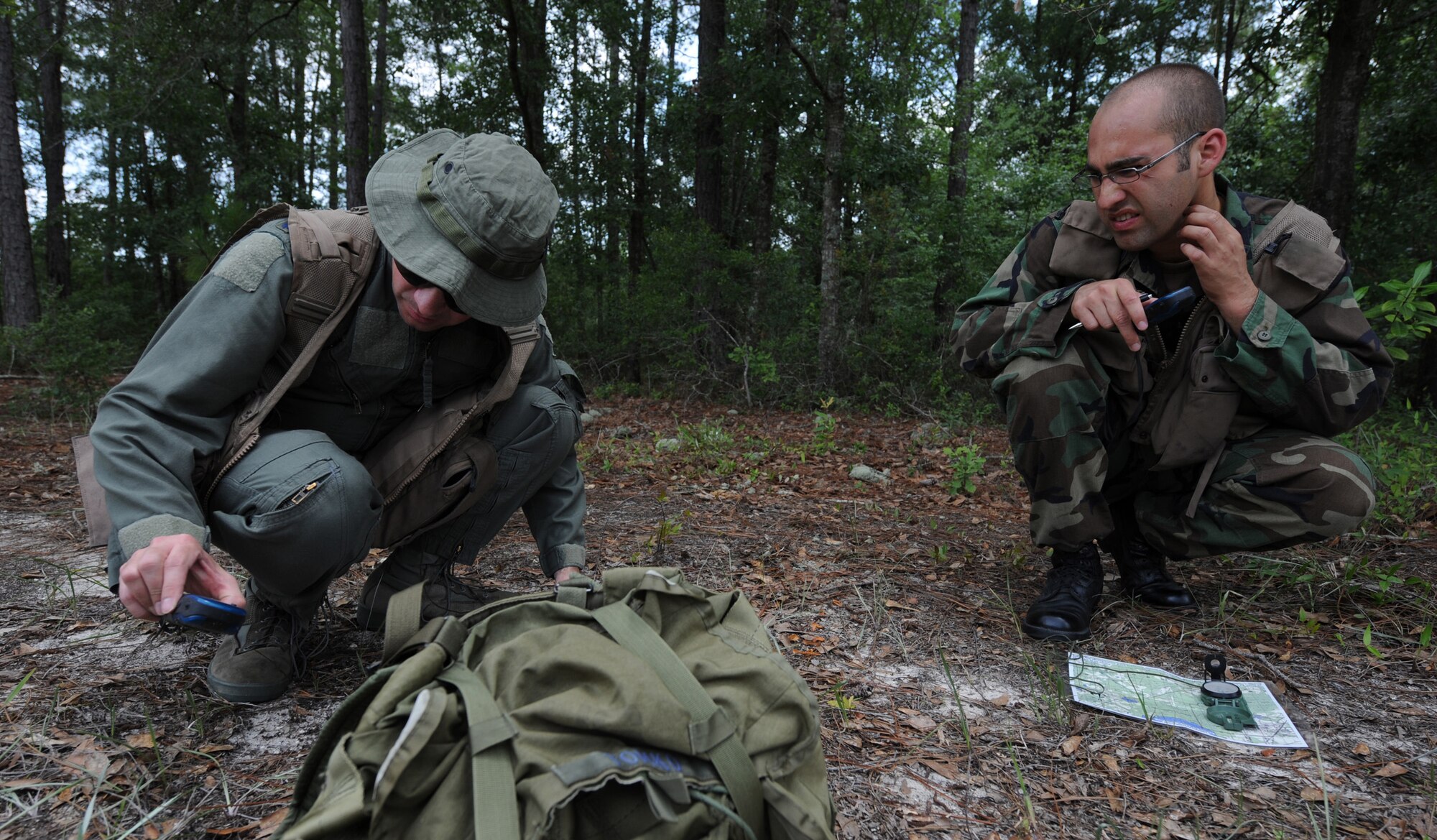 MOODY AIR FORCE BASE, Ga. -- Lt. Col. Charles Tomko, 347th Operations Support Squadron director of operations, left, and Capt. Michael Colom, 74th Fighter Squadron safety, begin to plot coordinates on a map during survival, evasion, resistance, escape (SERE) training here June 16. (U.S. Air Force photo by Senior Airman Gina Chiaverotti)