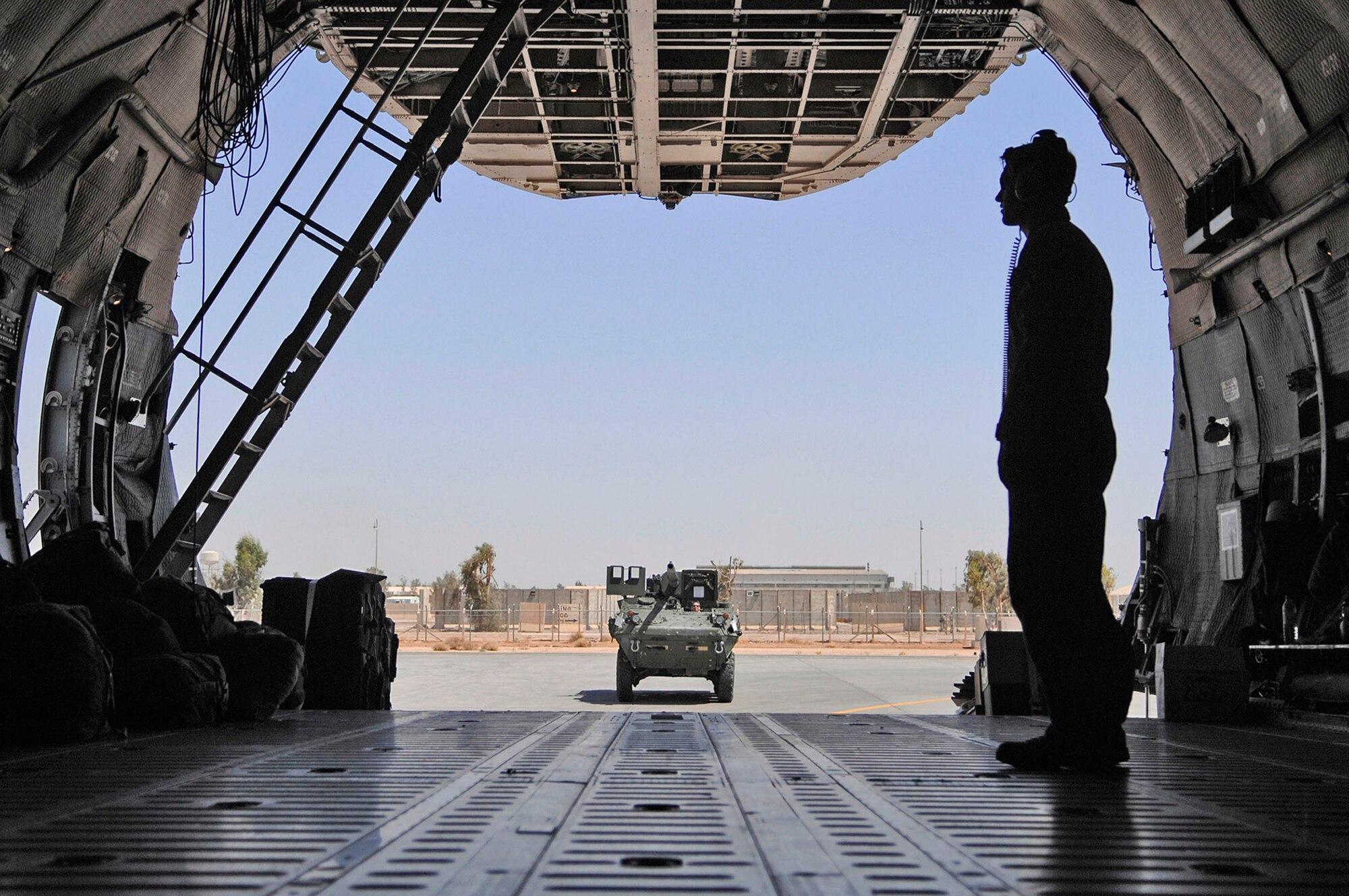 Tech. Sgt. Kurt Nemecek waits to usher an Army Stryker Infantry Carrier Vehicle onto a C-5 Galaxy June 25 at Joint Base Balad, Iraq. Two Strykers were loaded and headed to the Anniston Army Depot in Ala. The C-5 is mainly used to transport oversized cargo, and has a maximum capacity of 270,000 pounds. Sergeant Nemecek is a 9th Airlift Squadron flight engineer assigned to Dover Air Force Base, Del. (U.S. Air Force photo/Senior Airman Julianne Showalter) 
