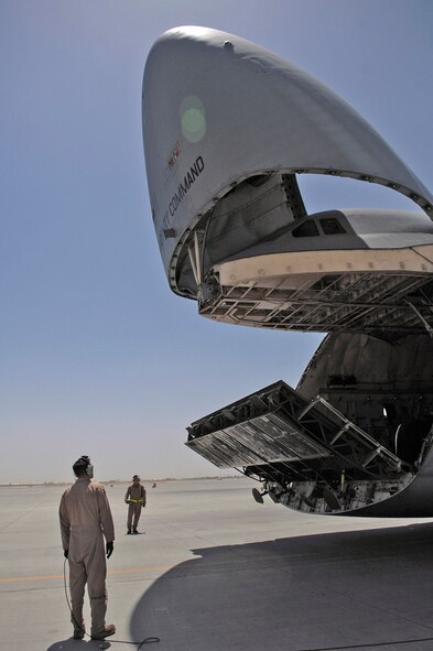 Tech. Sgt. Kurt Nemecek watches as the ramp of a C-5 Galaxy is lowered to load two Army Stryker Infantry Carrier Vehicles June 25 at Joint Base Balad, Iraq. The C-5 can carry all of the Army's air-transportable combat equipment. Sergeant Nemecek is a 9th Airlift Squadron flight engineer from Dover Air Force Base, Del. (U.S. Air Force photo/Senior Airman Julianne Showalter) 