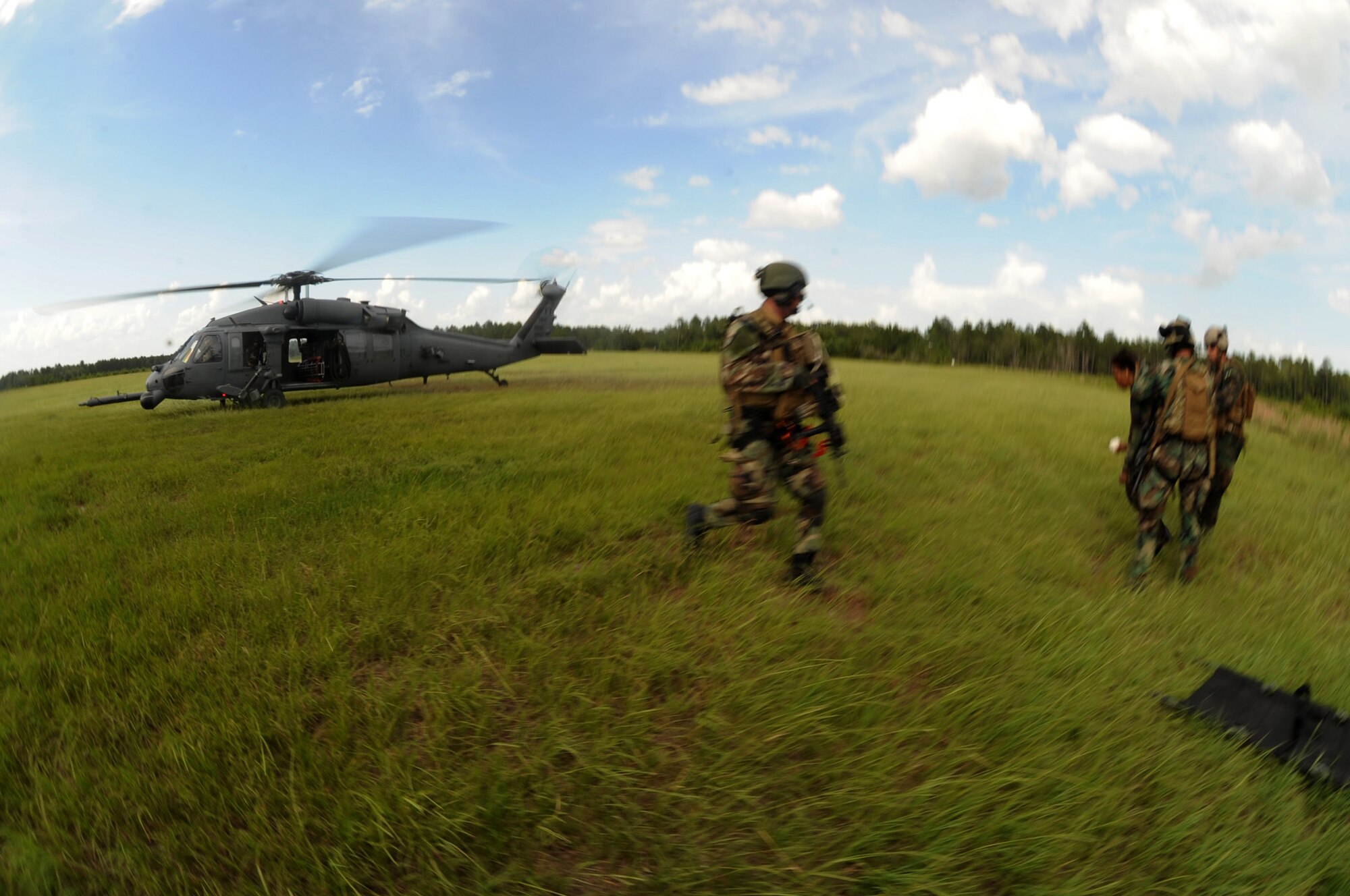 MOODY AIR FORCE BASE, Ga. -- 38th Rescue Squadron pararescuemen take a mock patient to a waiting HH-60G Pave Hawk during a mass casualty exercise here June 27. The patients were being transported to an HC-130P King for medical evacuation after a staged helicopter crash. (U.S. Air Force photo by Senior Airman Gina Chiaverotti)