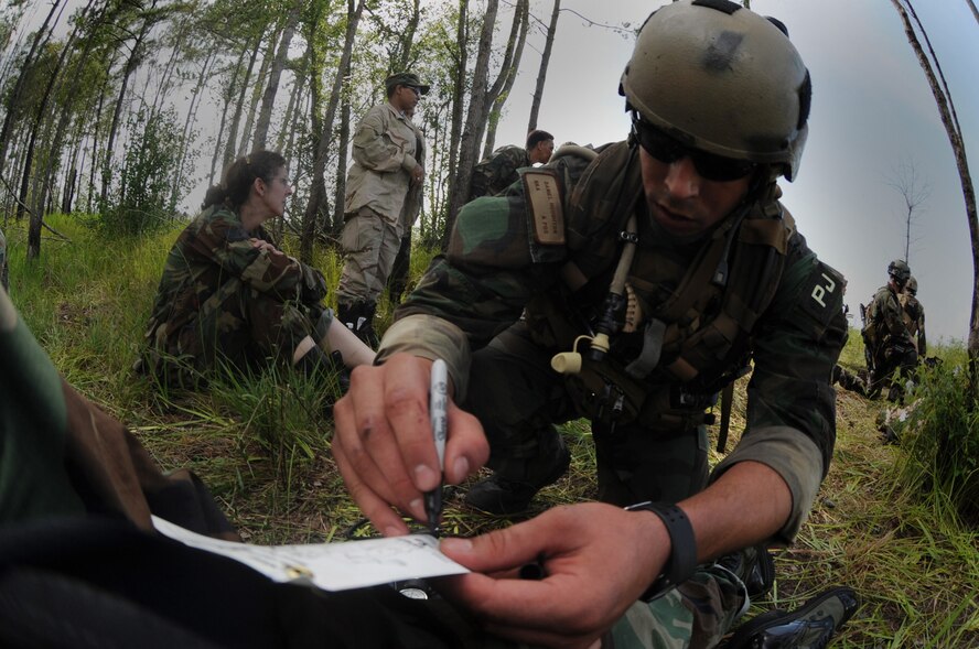 MOODY AIR FORCE BASE, Ga. -- Staff Sgt. Daniel Houghton, 38th Rescue Squadron pararescueman, write down a patient's vitals on a casualty information tag during a mass-casualty exercise here June 27. Pararescuemen treated a total of 25 mock casualties. (U.S. Air Force photo by Senior Airman Gina Chiaverotti)