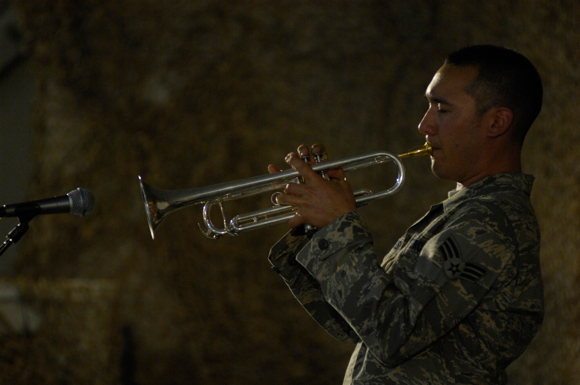 BAGRAM AIR FIELD, Afghanistan--Senior Airman Patrick Brush, U.S. Air Forces Band ‘Falcon’ trumpet player, captivates an audience with the smooth sounds of his trumpet during a show here June 22.  Airman Brush is deployed from the  USAF Heartland of America Band, Offutt AFB, Neb.   ‘Falcon’ travels throughout the area of responsibility positively promoting troop morale, diplomacy and reach out to host nation communities.  (U.S. Air Force Photo By/Master Sgt. Demetrius Lester)