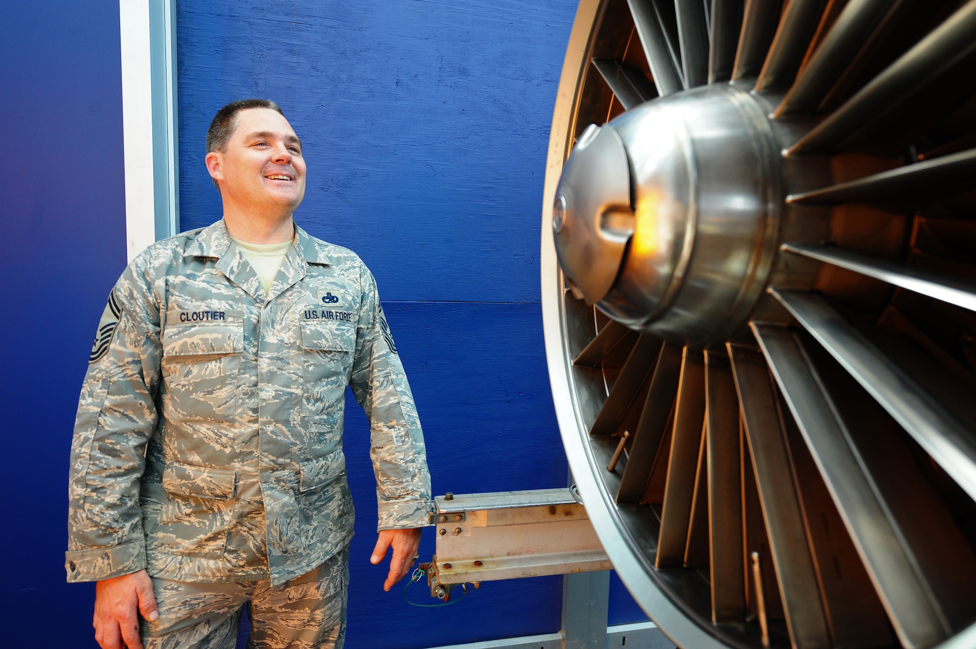 LANGLEY AIR FORCE BASE, Va. -- Senior Master Sgt. Scott Cloutier, 1st Component Maintenance Squadron propulsion flight chief, examines an F100-100 jet engine on display at the Virginia Air and Space Center June 27 The engine was loaned by the National Museum of the U.S. Air Force via Langley Air Force Base.  "It's a beautifully polished and clean engine," Sergeant Cloutier said. "I'd hate to see it go to the scrap yard." (U.S. Air Force photo/Staff Sgt. Barry Loo)