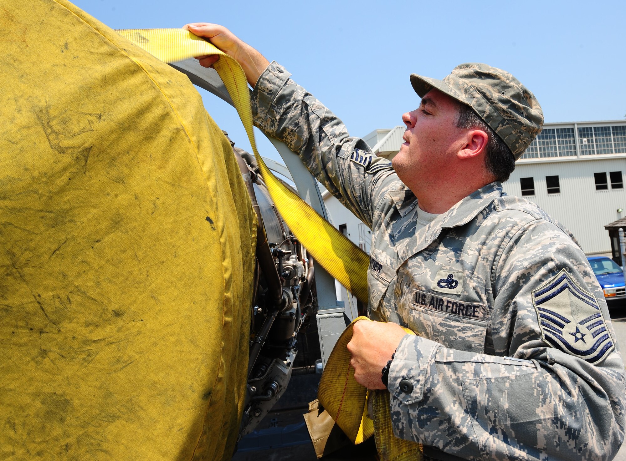 LANGLEY AIR FORCE BASE, Va. -- Senior Master Sgt. Scott Cloutier, 1st Component Maintenance Squadron propulsion flight chief, secures an F100-100 jet engine onto a truck destined for the Virginia Air and Space Center June 27.  The engine was loaned by the National Museum of the U.S. Air Force via Langley Air Force Base.  "It's a beautifully polished and clean engine," Sergeant Cloutier said. "I'd hate to see it go to the scrap yard." (U.S. Air Force photo/Staff Sgt. Barry Loo)