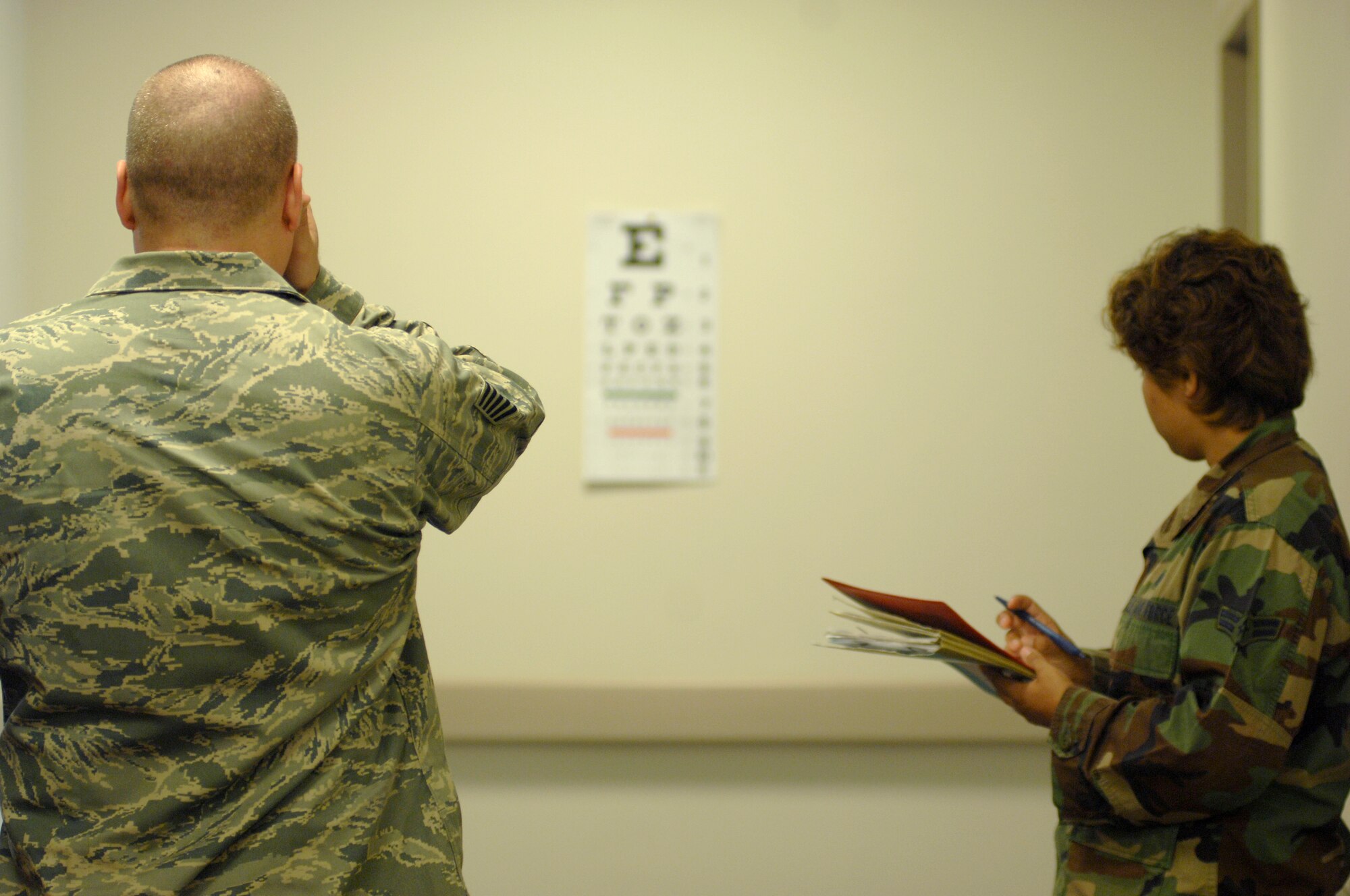 AVIANO AIR BASE, Italy --  Airman 1st Class Kristi Etchechury, 31st Medical Operations Squadron, conducts an eye exam as a part of Tech. Sgt. Douglas McDivitt's Preventitive Health Assessment June 26.  The eye exam is just one part of a PHA to see if Airmen need glasses and gas mask inserts.  (U.S. Air Force photo/Airman 1st Class Ashley Wood)