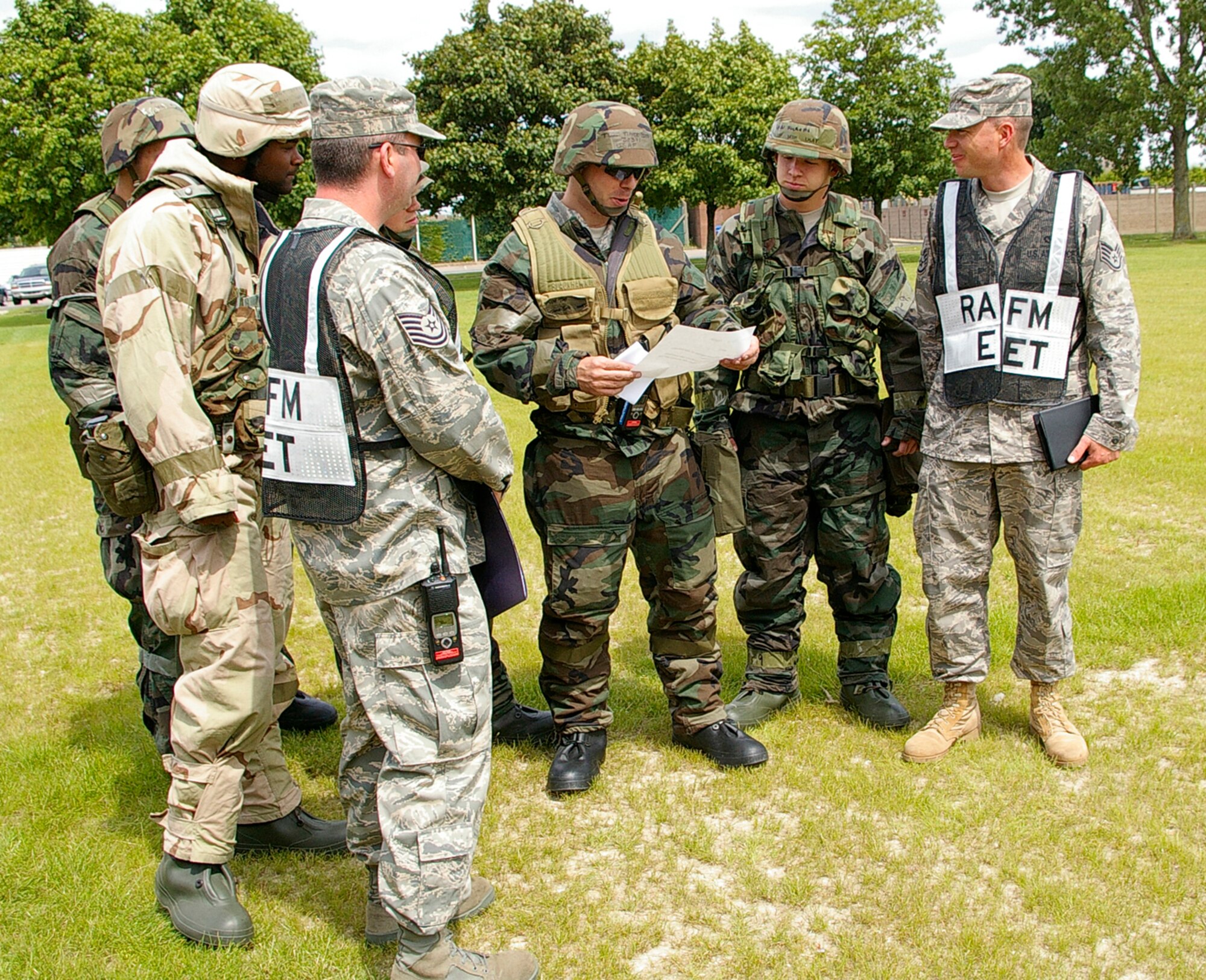 Airmen from a simulated damage assessment recovery team are handed an exercise inject during a Phase II exercise at RAF Mildenhall June 24.  The scenario simulated damage to the building, with windows smashed and water lines damaged. The 100th Civil Engineer Squadron team was expected to fix the problems, from turning off the water supply to fix leaks to repairing any severed electricity cables. (U.S. Air Force photo by Karen Abeyasekere)