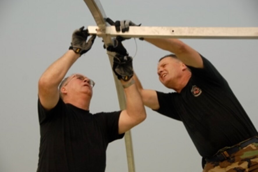 Tech. Sgt. Gary Risen and Lt. Col. Bill Adkisson of the 123rd Medical Group connect beams used in the support structure of EMEDS facilities.