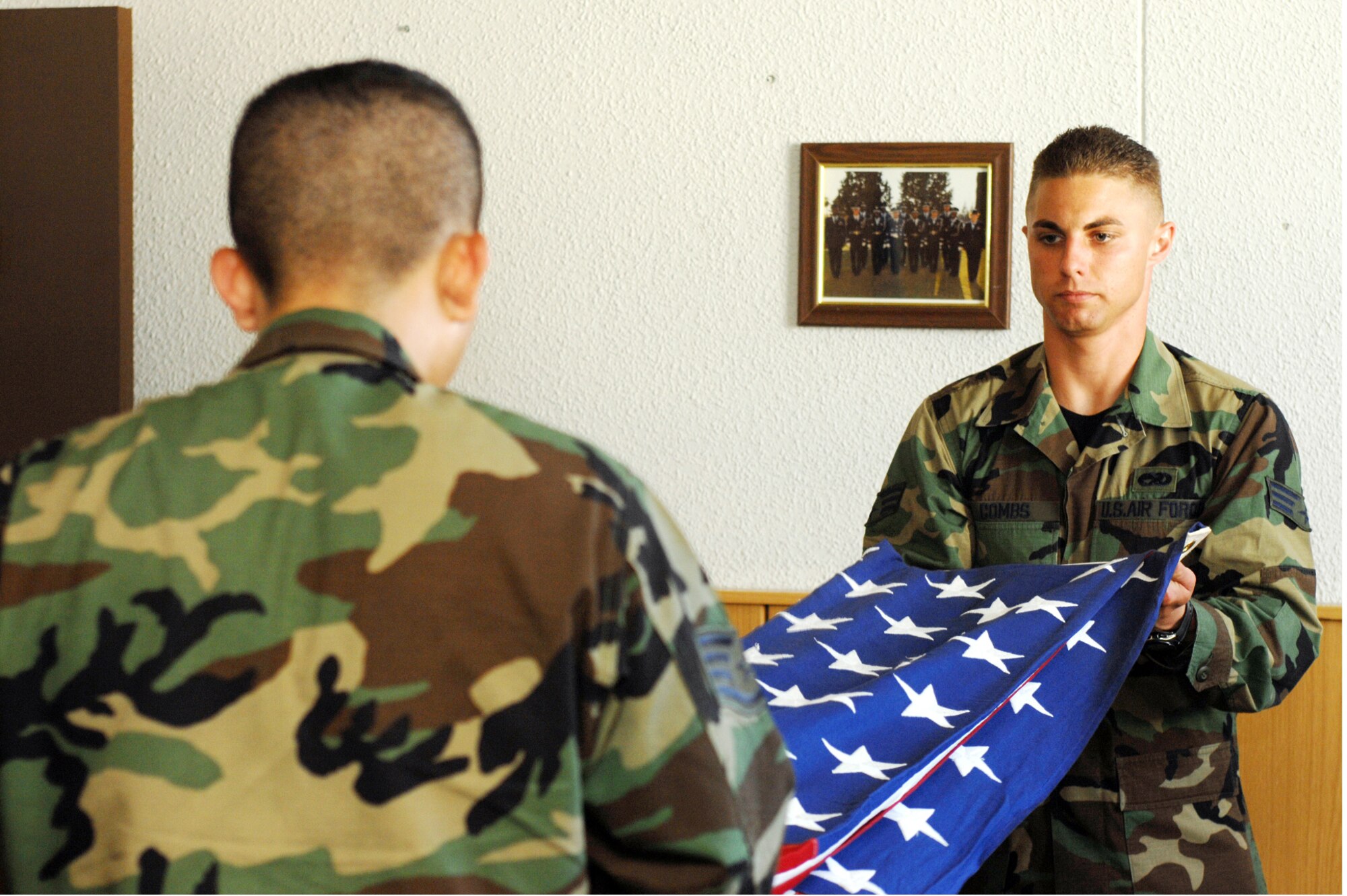 Senior Airman Adam Combs, Incirlik Honor Guard member, holds the flag as Staff Sgt. Sergio Garcia, Honor Guard trainer, demonstrates procedures for the two-man flag fold. (United States Air Force photo by Staff Sgt. Jeff Nevison)
