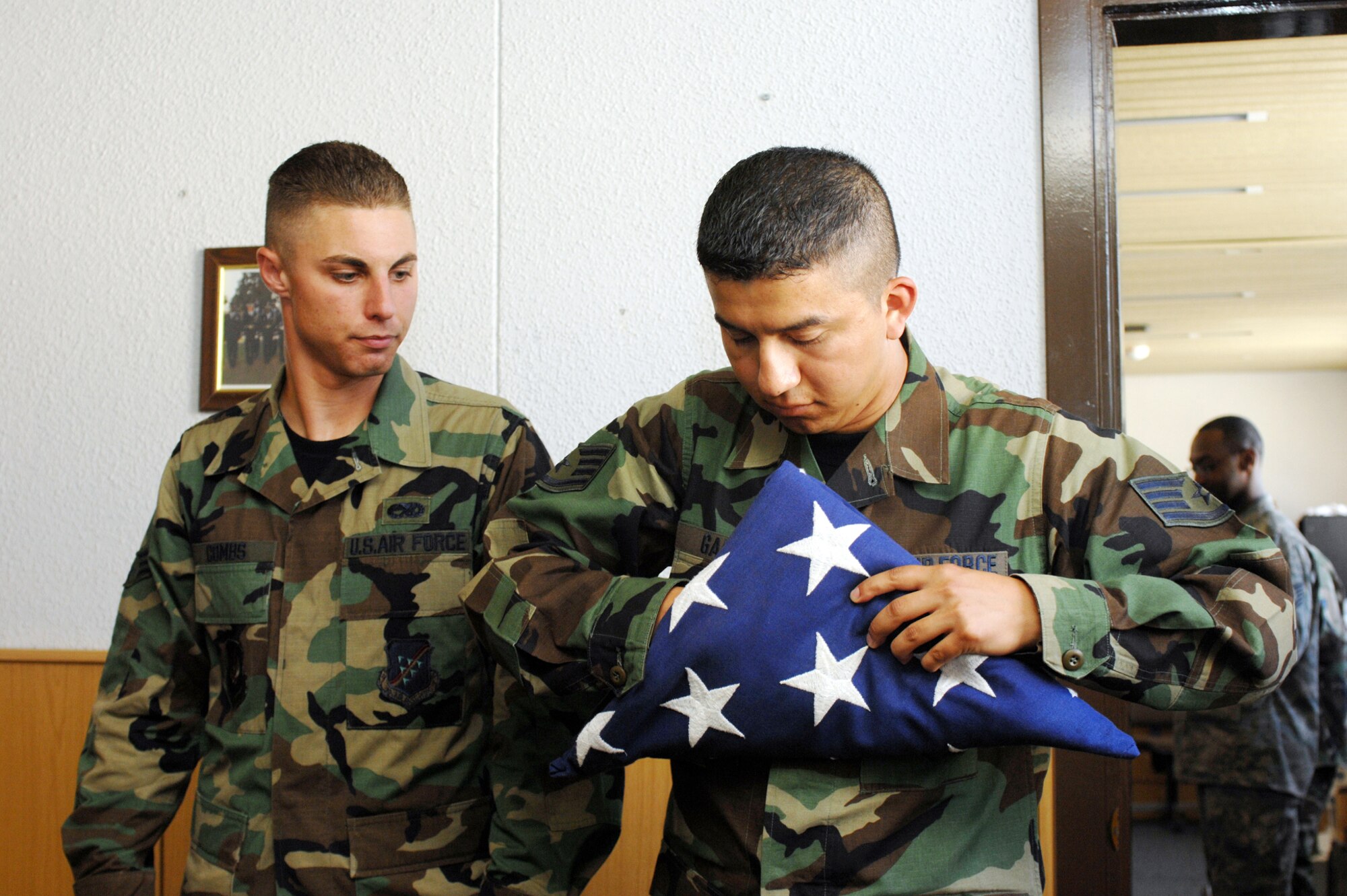 Staff Sgt. Sergio Garcia, Honor Guard trainer, show Senior Airman Adam Combs, Incirlik Honor Guard member, how to properly dress the flag for a retirement ceremony. (United States Air Force photo by Staff Sgt. Jeff Nevison)