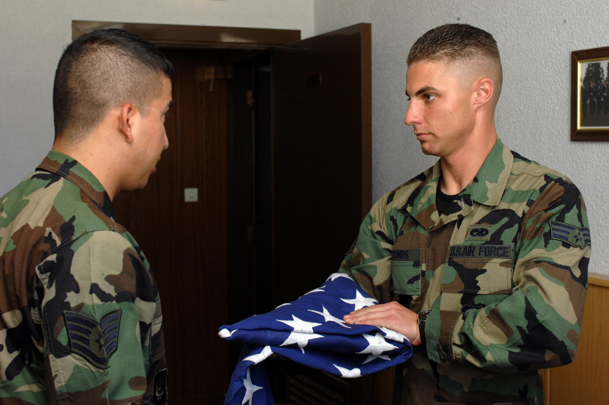 Senior Airman Adam Combs, Incirlik Honor Guard member, is trained by Staff Sgt. Sergio Garcia, Honor Guard trainer, on the two-man flag fold June 24 in building 480. The team practices every Tuesday from 3-6 p.m. (United States Air Force photo by Staff Sgt. Jeff Nevison)