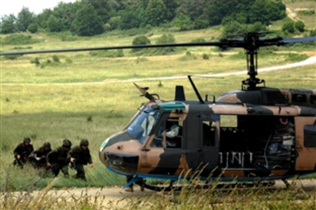 A U.S. Army UH-1 helicopter lands to pick up a group of German soldiers during U.S.-German Army partnership air assault training at the Joint Multinational Readiness Center in Hohenfels, Germany, June 25, 2008.  