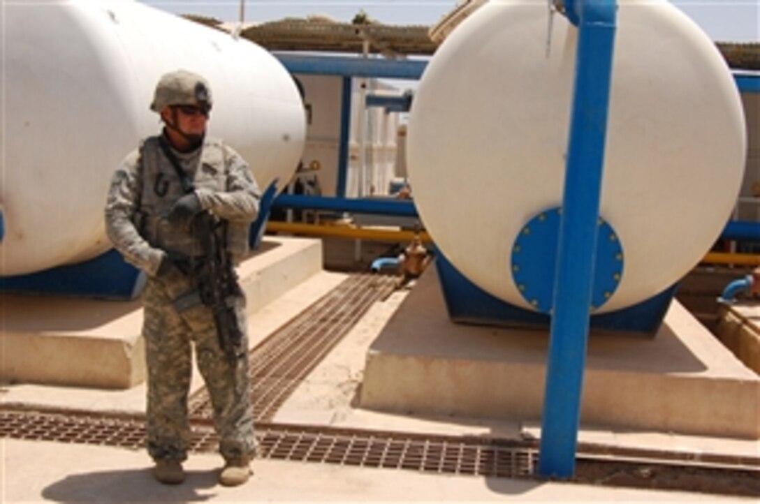 U.S. Army Spc. Timothy Russell provides security at a water treatment facility in Taji Qada, northwest of Baghdad, June 26, 2008, as military leaders discuss ways to improve the output of portable water to the residents the area. Russell is assigned to the 25th Infantry Division's Headquarters and Headquarters Company, 1st Battalion, 27th Infantry Regiment.