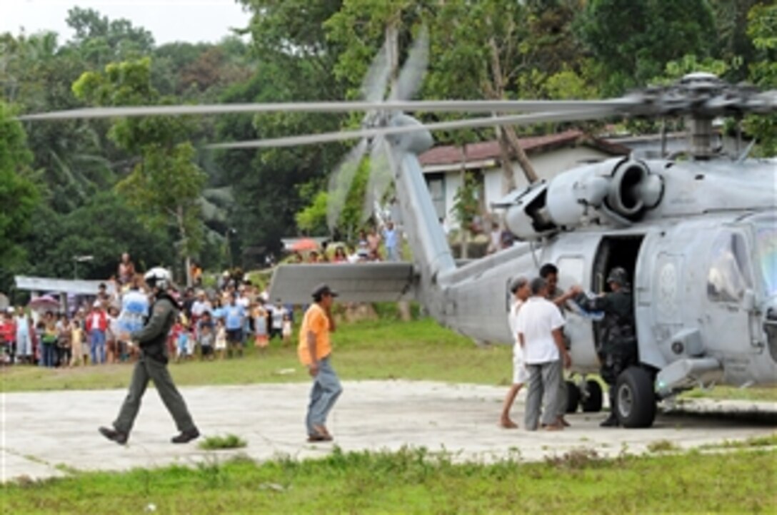 Residents help U.S. and Philippine service members unload water and humanitarian supplies from a helicopter on Panay Island in the Philippines on June 27, 2008.  The helicopter is assigned to Helicopter Anti-Submarine Squadron 4, Carrier Air Wing 14, which is embarked aboard the Nimitz-class aircraft carrier USS Ronald Reagan (CVN 76).  The Ronald Reagan Carrier Strike Group is providing humanitarian assistance and disaster relief to victims of Typhoon Fengshen, which struck the Philippines on June 23, 2008.  