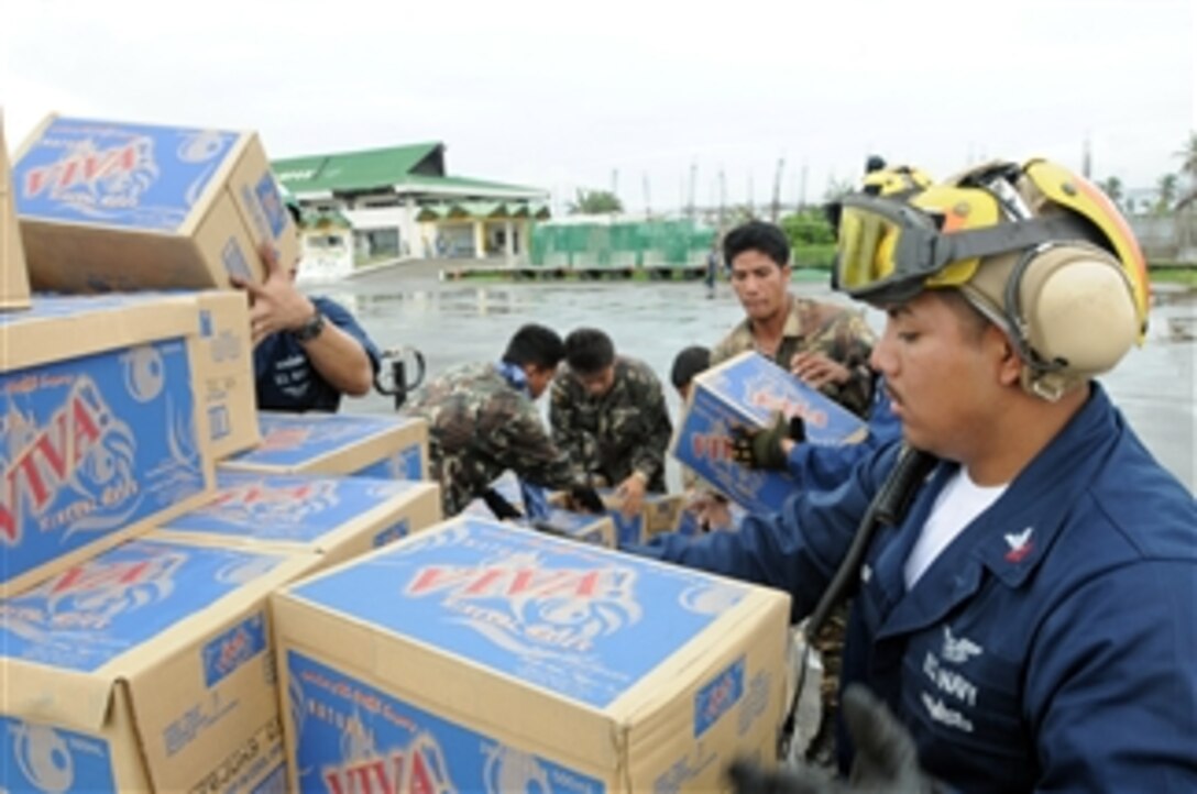 U.S. Navy Petty Officer 2nd Class William Sum and Philippine service members unload bottled water for the residents of Kalibo, Philippines, on June 29, 2008.  Sum and other U.S. sailors assigned to the USS Ronald Reagan Carrier Strike Group are providing humanitarian assistance and disaster relief to victims of Typhoon Fengshen, which struck the Philippines on June 23, 2008.  