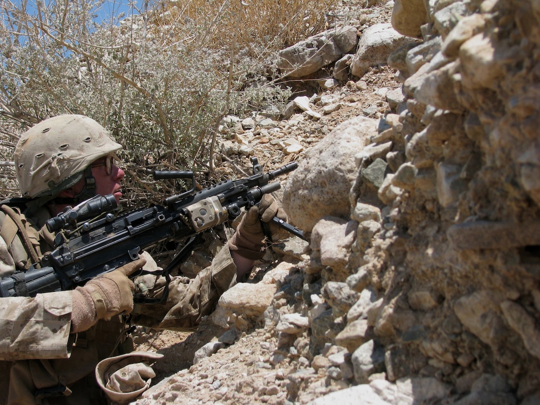 Lance Cpl. Randy Freed, a Reserve Marine from Echo Company 2nd Bn., 25th Marines, takes up a security position with his M249 Squad Automatic Weapon on the edge of a dry ravine running through Range 400 here June 30, 2008.  The Marines conducted the rehearsal in mid-day temperatures topping 110 degrees in preparation for the following day's live-fire exercise.