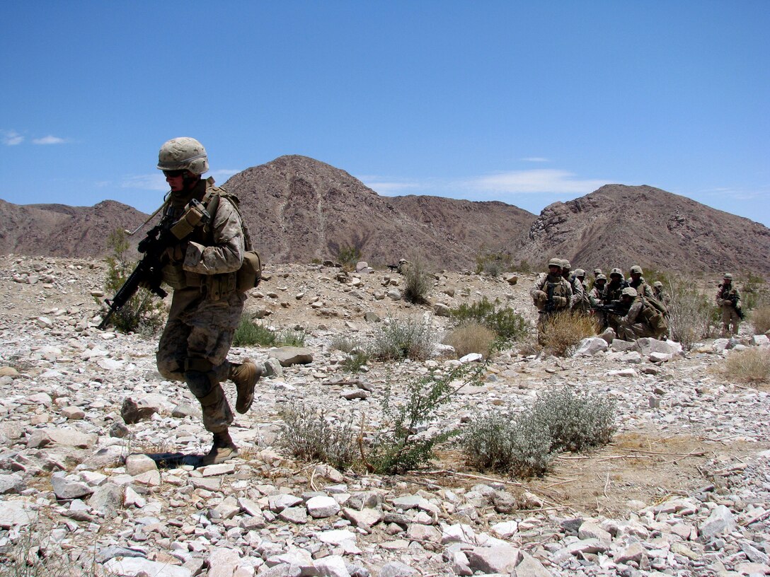 Lance Cpl. Christopher Slutman, a team leader with Company E, rushes across a danger area as he moves with his platoon through a grueling fire and maneuver course on Range 400 at Twentynine Palms, Calif., June 30, 2008.   In addition to being a physical conditioning tool for the Reserve Marines bound for Iraq in the fall, the course focused on small-unit leadership skills and squad communication.