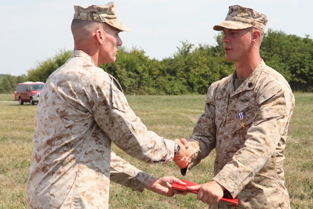 Maj. Gen. James M. Lariviere, former commanding general for the 4th Marine Division, congratulates Staff Sgt. Alec Haralovich, after presenting him the Silver Star Medal, the nation?s third highest award for combat valor. After Haralovich was shot twice in his body armor by an insurgent, he destroyed an enemy stronghold with a rocket and led his Marines on a two-hour assault after their ambushers during an Afghanistan deployment in 2011. Haralovich is a reconnaissance Marine assigned to E Company, 4th Reconnaissance Bn., 4th Marine Division.