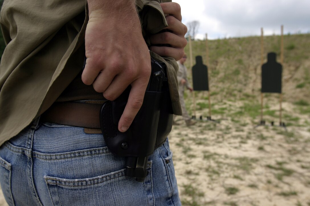 A Marine with Marine Special Operations Advisor Group, U.S. Marine Corps Forces, Special Operations Command, practices drawing an M9 9mm service pistol from a concealed position during the Defensive Pistol Course at the Military Operations In Urban Terrain Assault Course here, June 30 through July 1.