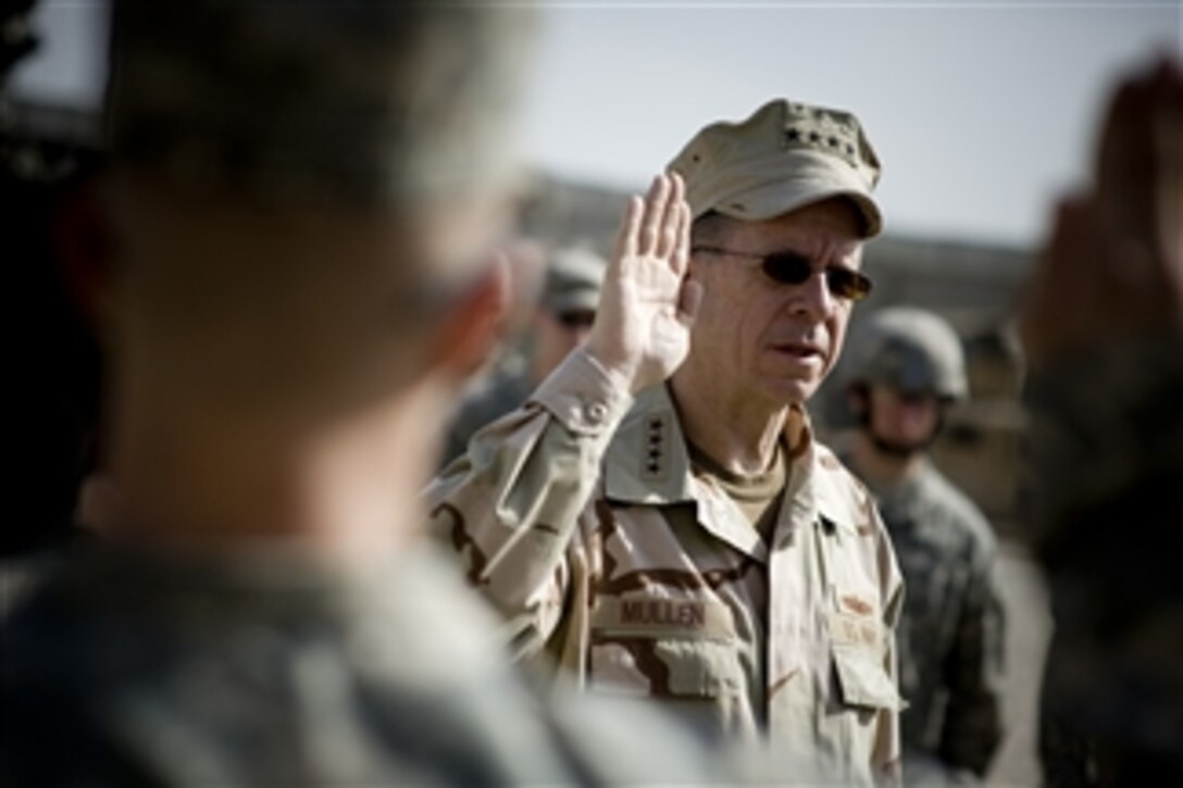 Adm. Mike Mullen, chairman of the Joint Chiefs of Staff, reenlists 1st Infantry Division soldiers at Combat Outpost Banchee, in Rashid, Iraq, March 1, 2008. Mullen took a tour and visited locals in the once volatile Baghdad neighborhood that was an Al-Qaeda stronghold and now is a model of reform in Iraq. 