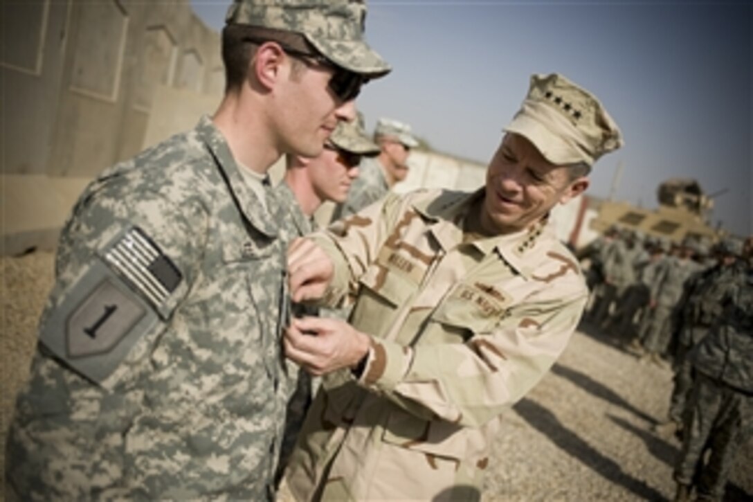 Adm. Mike Mullen, chairman of the Joint Chiefs of Staff, promotes 1st Lt. Travis Lee to Army captain during a ceremony at Combat Outpost Banchee, in Rashid, Iraq, March 1, 2008. 
