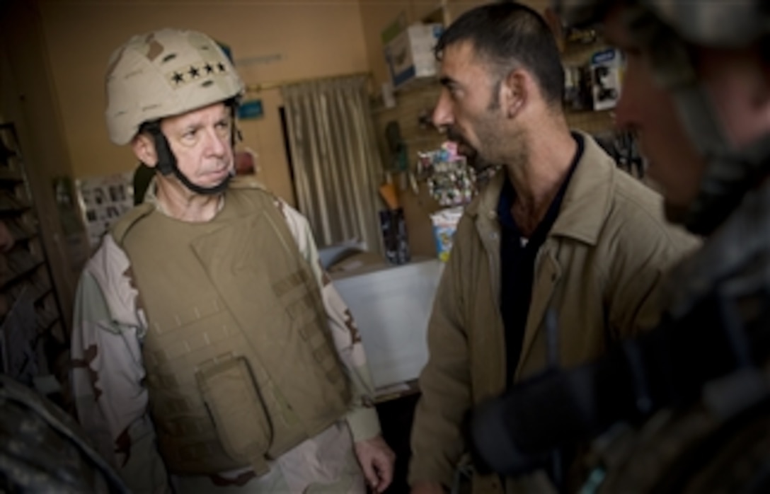U.S. Navy Adm. Mike Mullen, chairman of the Joint Chiefs of Staff, visits with a local shop owner in the Airplane Road business district in Rashid, Iraq, March 1, 2008.  