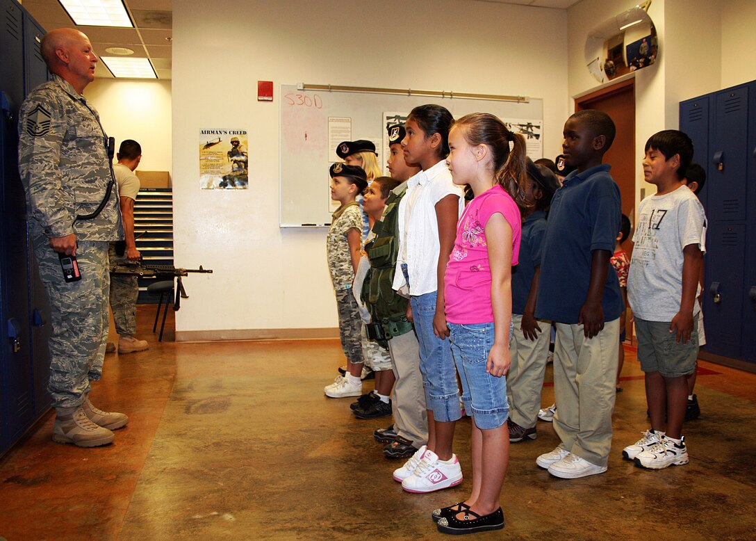 Senior Master Sgt. Ray Johnson, 36th Security Forces Squadron operations superintendent, conducts a Junior Defender guardmount during the 36th SFS's Junior Defender Day recently. (U.S. Air Force courtesy photo)