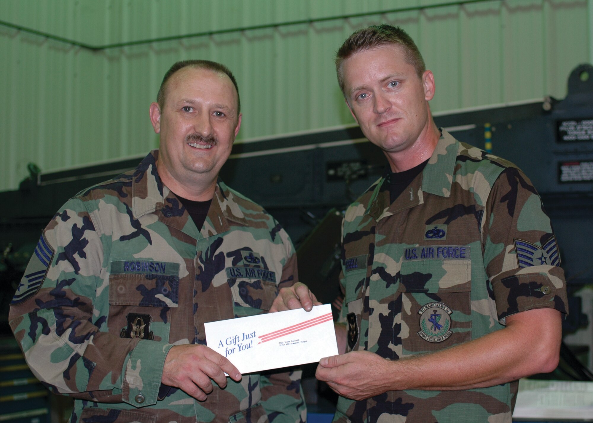 Chief Master Sgt. Tommy Robinson, 917th Maintenance Squadron, presents a gift to Tech. Sgt. Brent Russell, 917 MXS, from the Barksale Chief's Group June 7, 2007. (U.S. Air Force photo/Staff Sgt. Ebony Nichols)