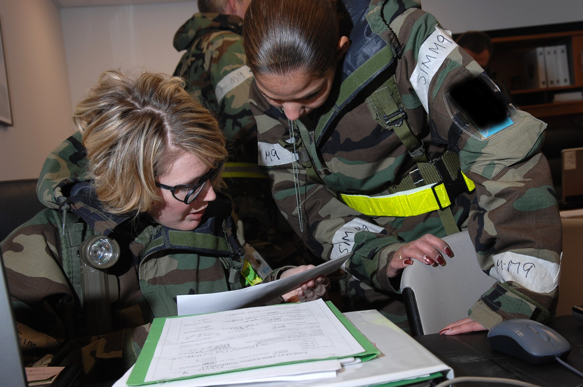 MOUNTAIN HOME AIR FORCE BASE, Idaho - Tech. Sgt. Amber Robbins, 366th Mission Support Squadron personnel in support of contingency operations casualty affairs representative, reviews records with Staff Sgt. Magda Andino, 366th MSS PERSCO noncommissioned officer in charge of separations, during Exercise Sharpshooter 08-04.1 March 1. PERSCO's main responsibility during the Phase II portion of the exercise is accountability of all personnel. The 366th Fighter Wing conducts exercises to prepare personnel and equipment for the upcoming March 2008 Operational Readiness Inspection. (U.S. Air Force photo/ Staff Sgt. Kathy Parker)