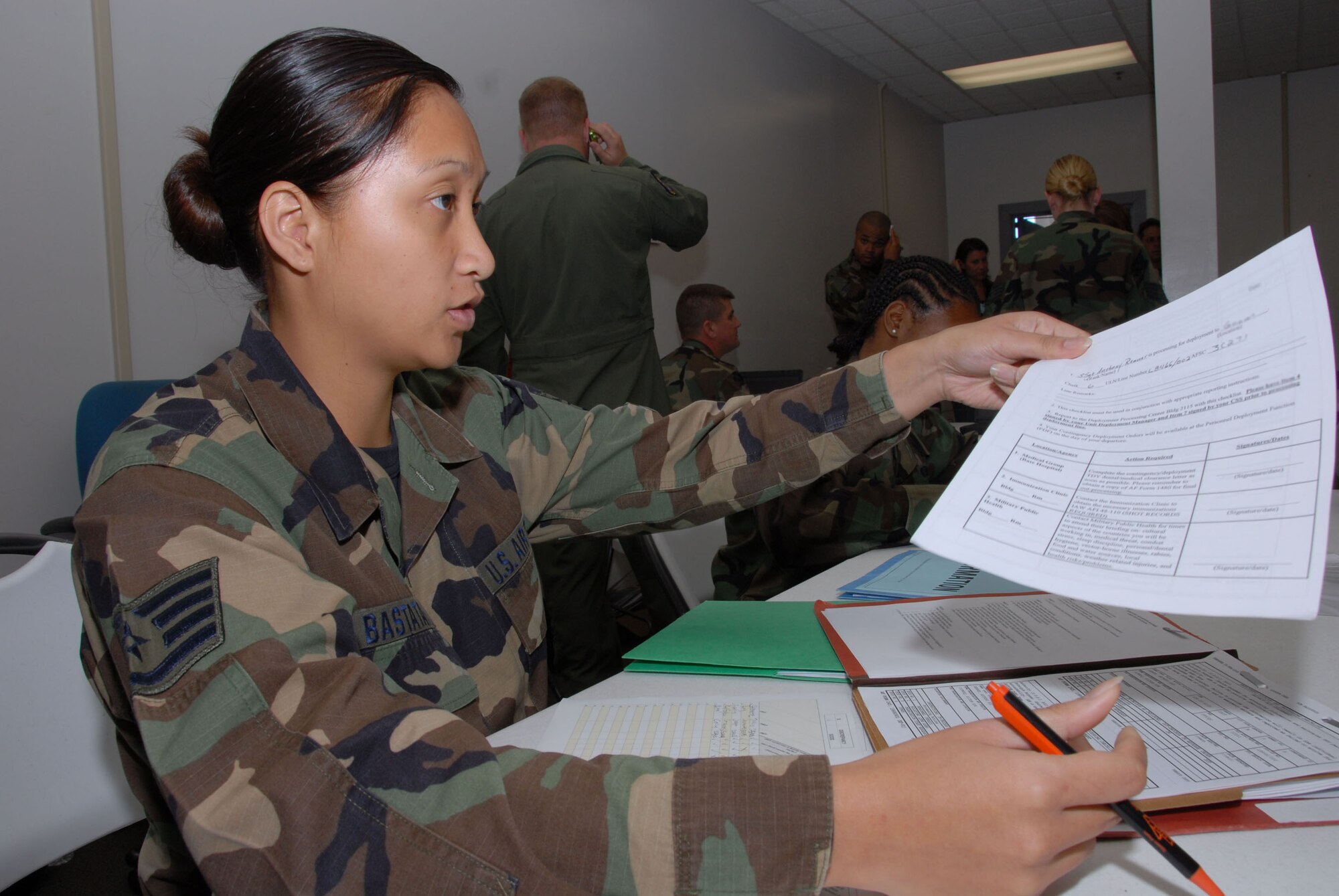 Staff. Sgt. Veronica Bastatas inspects paperwork during a recent exercise at Hickam, Hawaii. Photo by Ed Foster