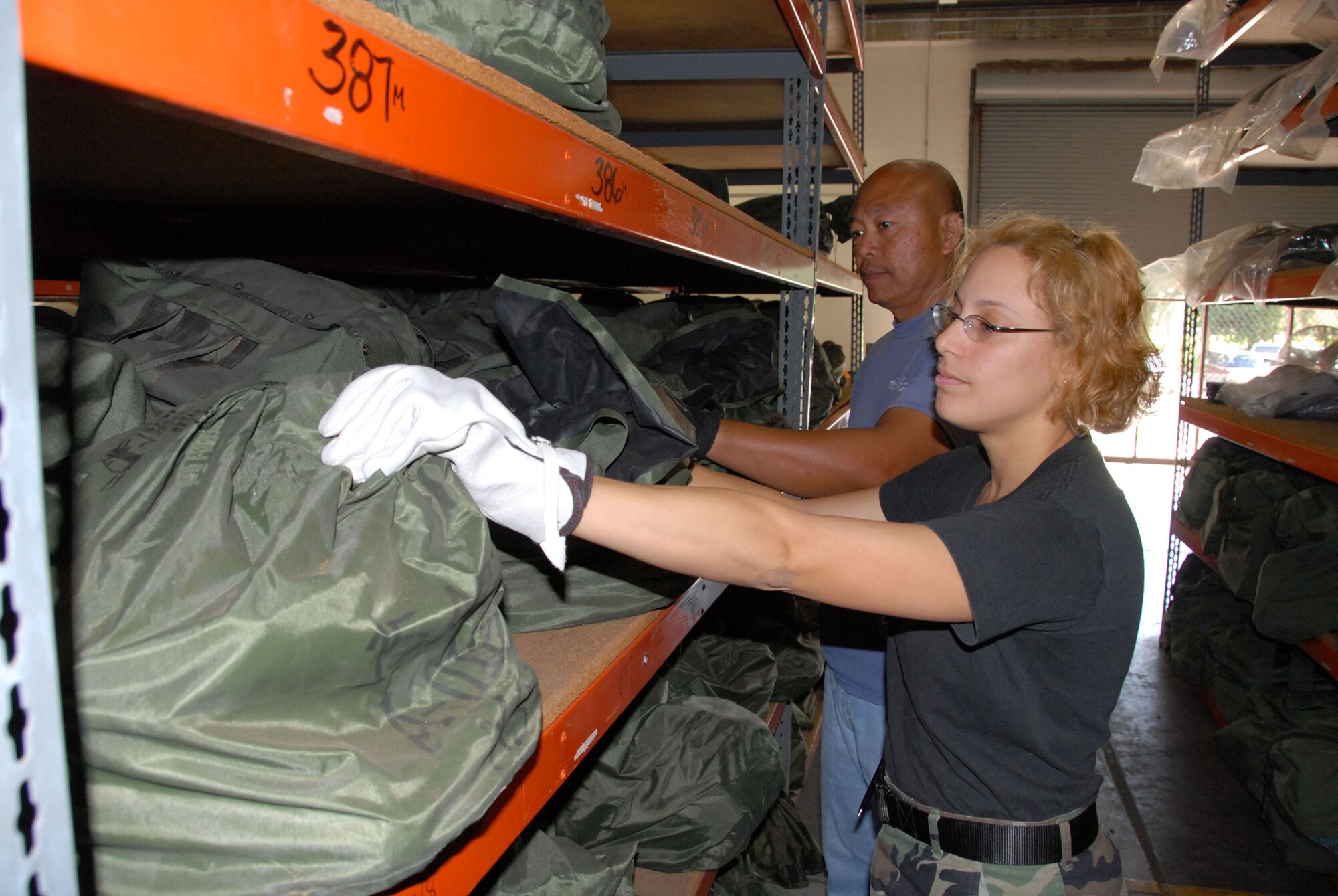 Airman 1st Class Sheila Rosado-Smith and Mr. Paul Mamarca check mobility bags during the joint 15th Airlift Wing/154th Wing, Hawaii Air National Guard deployment exercise held at Hickam AFB, Hawaii. Photo by Ed Foster