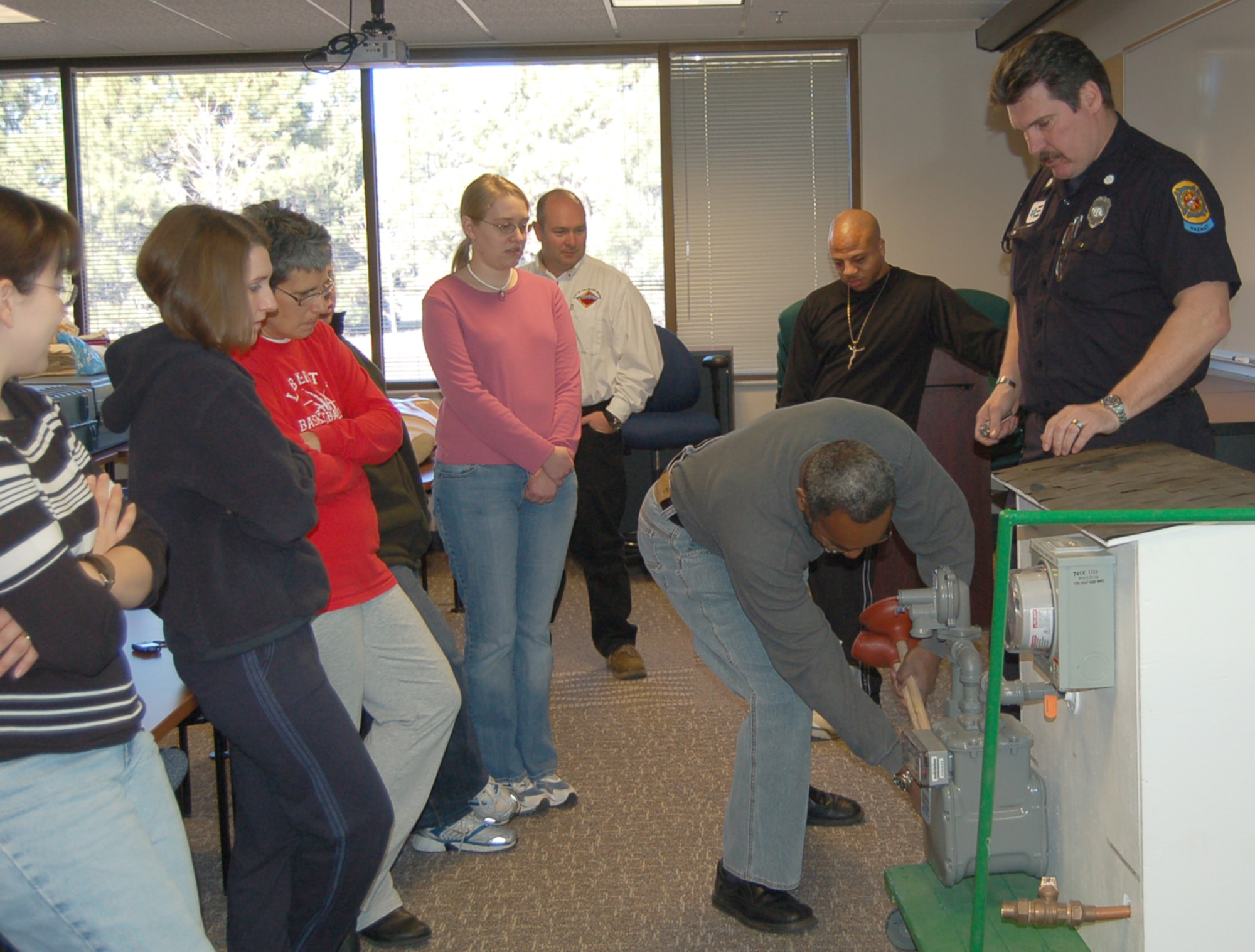 Capt. Gary Mittelstadt, Colorado Springs Fire Department, talks to participants of the citizen emergency response team, or CERT class about how to shut off a house’s gas and water. About 20 people attended the class, which taught about topics such as disaster preparedness, light search and rescue and fire safety. (U.S. Air Force photo/Corey Dahl) 