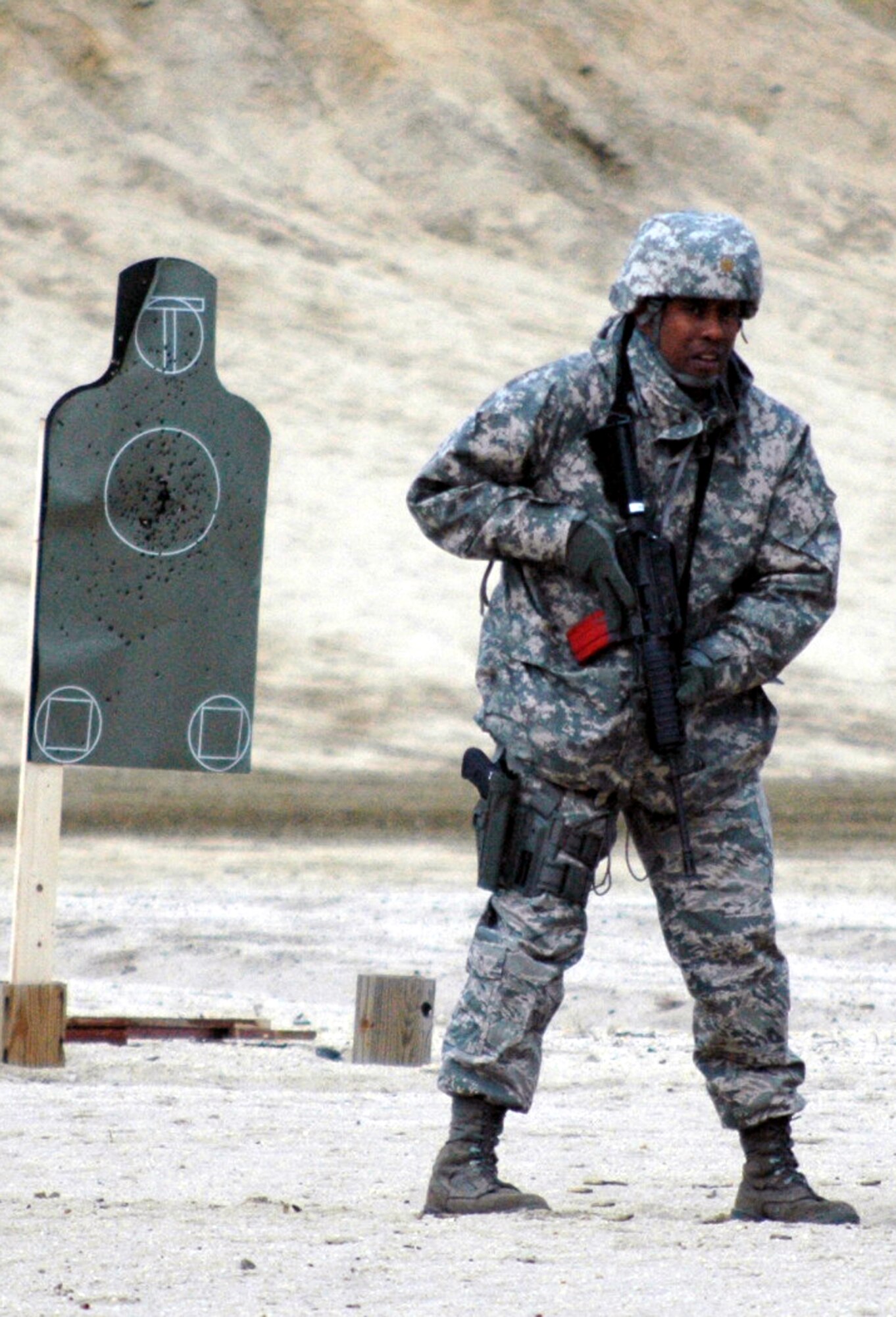 Maj. Kingston Lampley waits for his next instructions to shoot during tactical live fire training with an M-4 and M-9 on a range on Fort Dix, N.J., Feb. 27, 2008, as part of training in the Air Advisor Course 08-1.  The course is taught by the U.S. Air Force Expeditionary Center's Expeditionary Operations School and guest instructors preparing Airmen for their roles in training forces in Afghanistan and Iraq.  Major Lampley is from MacDill Air Force Base, Fla.  (U.S. Air Force Photo/Tech. Sgt. Scott T. Sturkol)