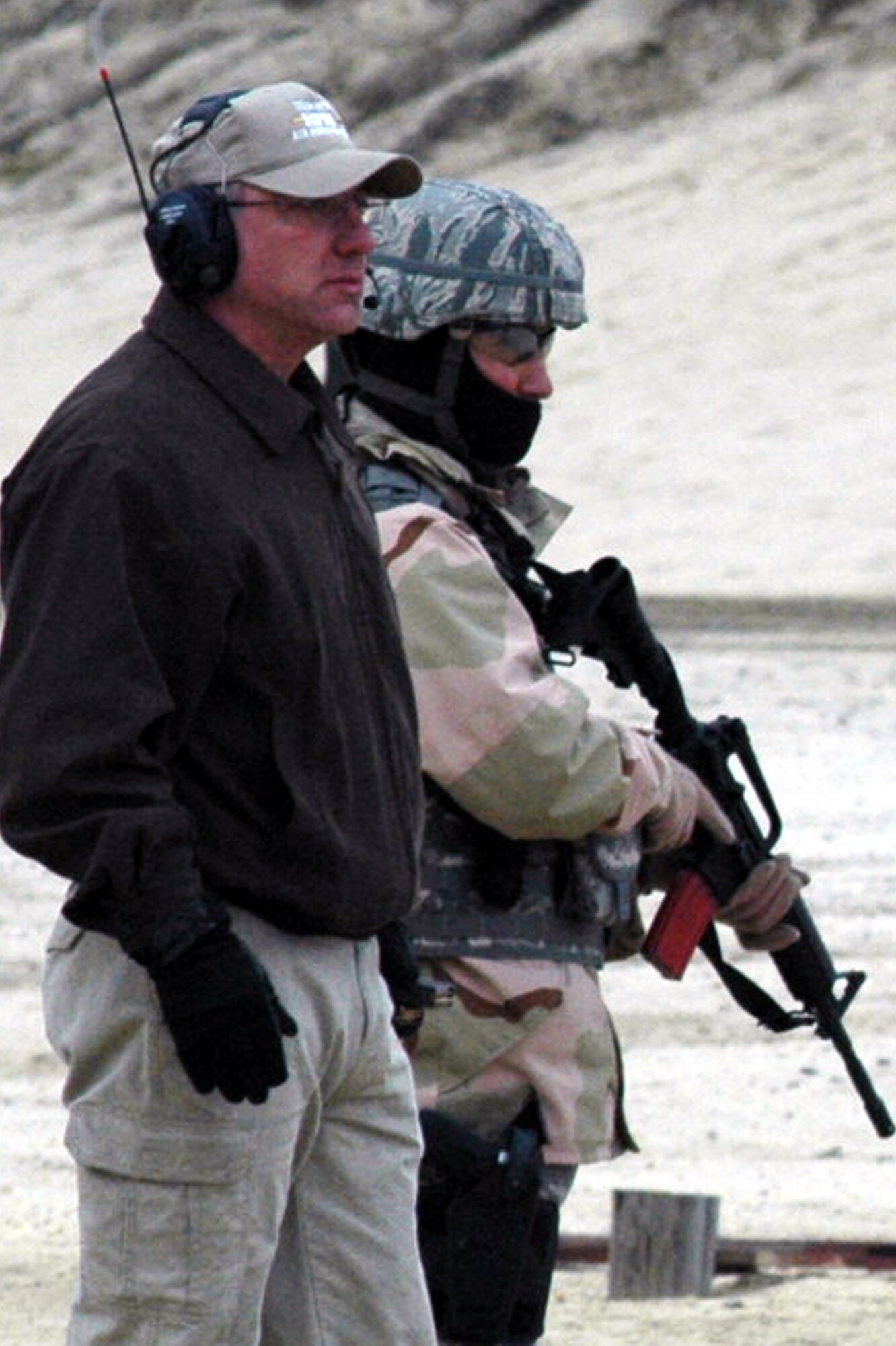 Mr. Jack Smith, a retired Air Force master sergeant, assists students in the U.S. Air Force Expeditionary Center's Air Advisor Course 08-1 during tactical live fire training with an M-4 and M-9 on a range on Fort Dix, N.J., Feb. 27, 2008.  The course is taught by the Center's Expeditionary Operations School and guest instructors.  The students in the course will be  deploying in the near future to help train forces in both Afghanistan and Iraq.  (U.S. Air Force Photo/Tech. Sgt. Scott T. Sturkol)