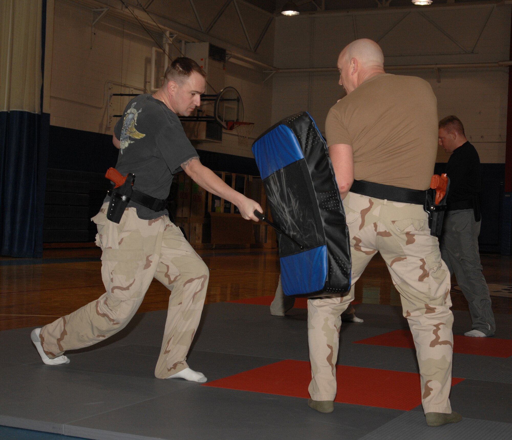 WHITEMAN AIR FORCE BASE, Mo-- Officer Matt Dunkle, Chenega Company, performs a forward strike while Officer Doug Austin, Chenega Company, holds the striking shield during a self defense class taught by civilian instructor Billy Matheny, 509th Security Forces, Feb. 20. This class is part of 70 hours of training that all new civilian security officers are required to have upon being hired. (U.S. Air Force photo/ Senior Airman Stephanie Clark)